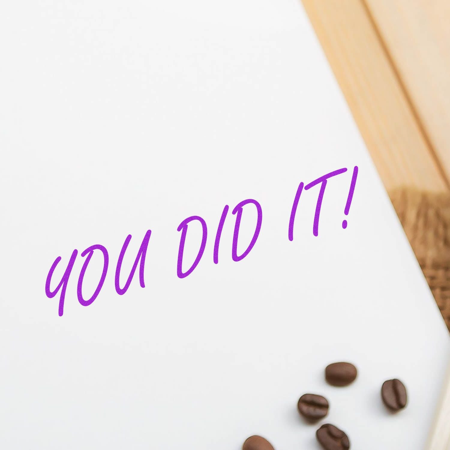 Slim Pre-Inked You Did It Stamp in purple ink on white paper, with coffee beans scattered on a wooden surface.