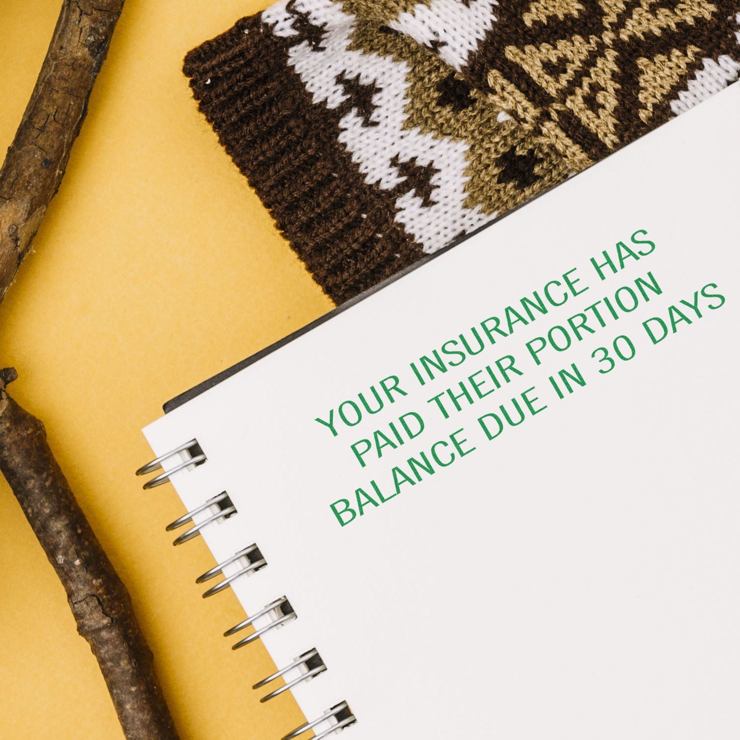 Large Self Inking Your Insurance Has Paid Their Portion Stamp used on a notebook, with text in green ink, next to a patterned fabric and sticks.