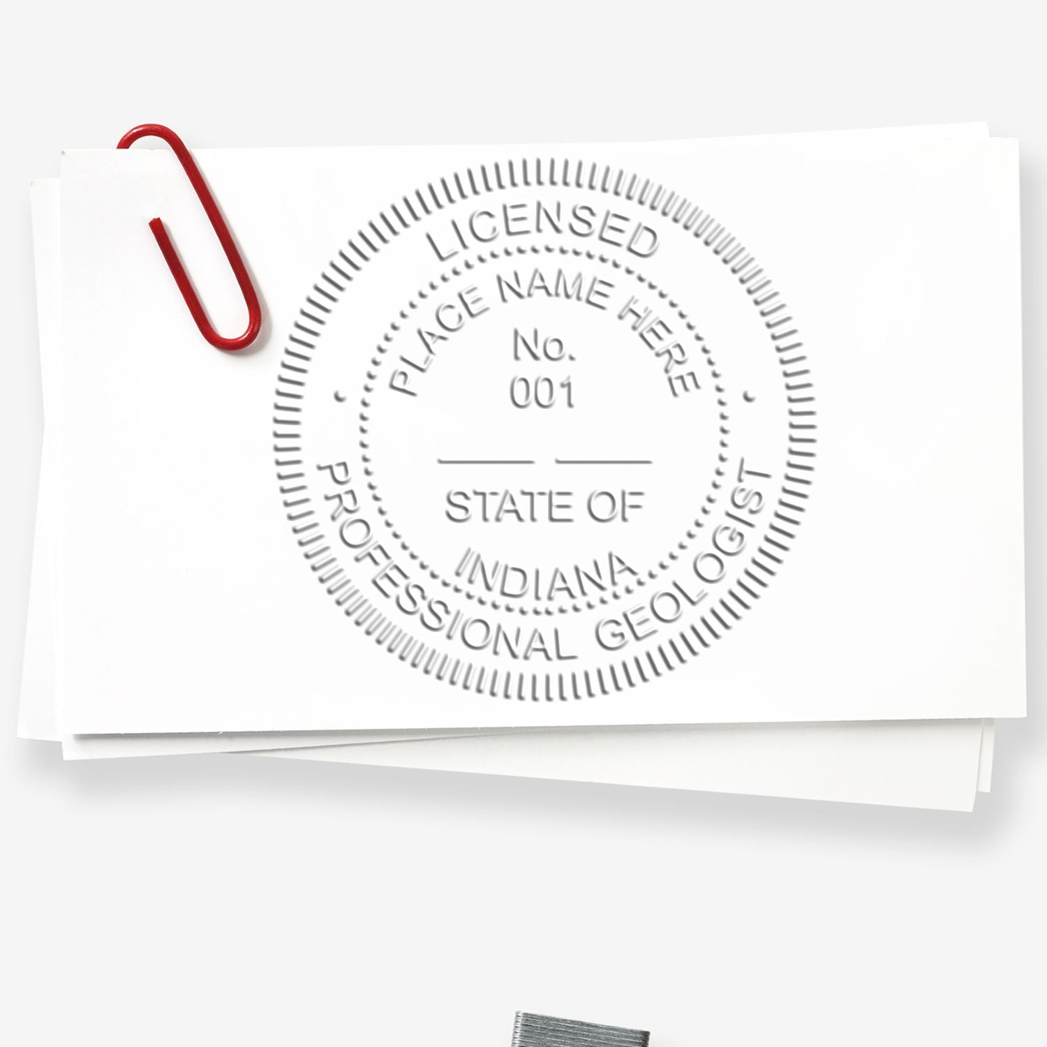 A lifestyle photo showing a stamped image of the Heavy Duty Cast Iron Indiana Geologist Seal Embosser on a piece of paper