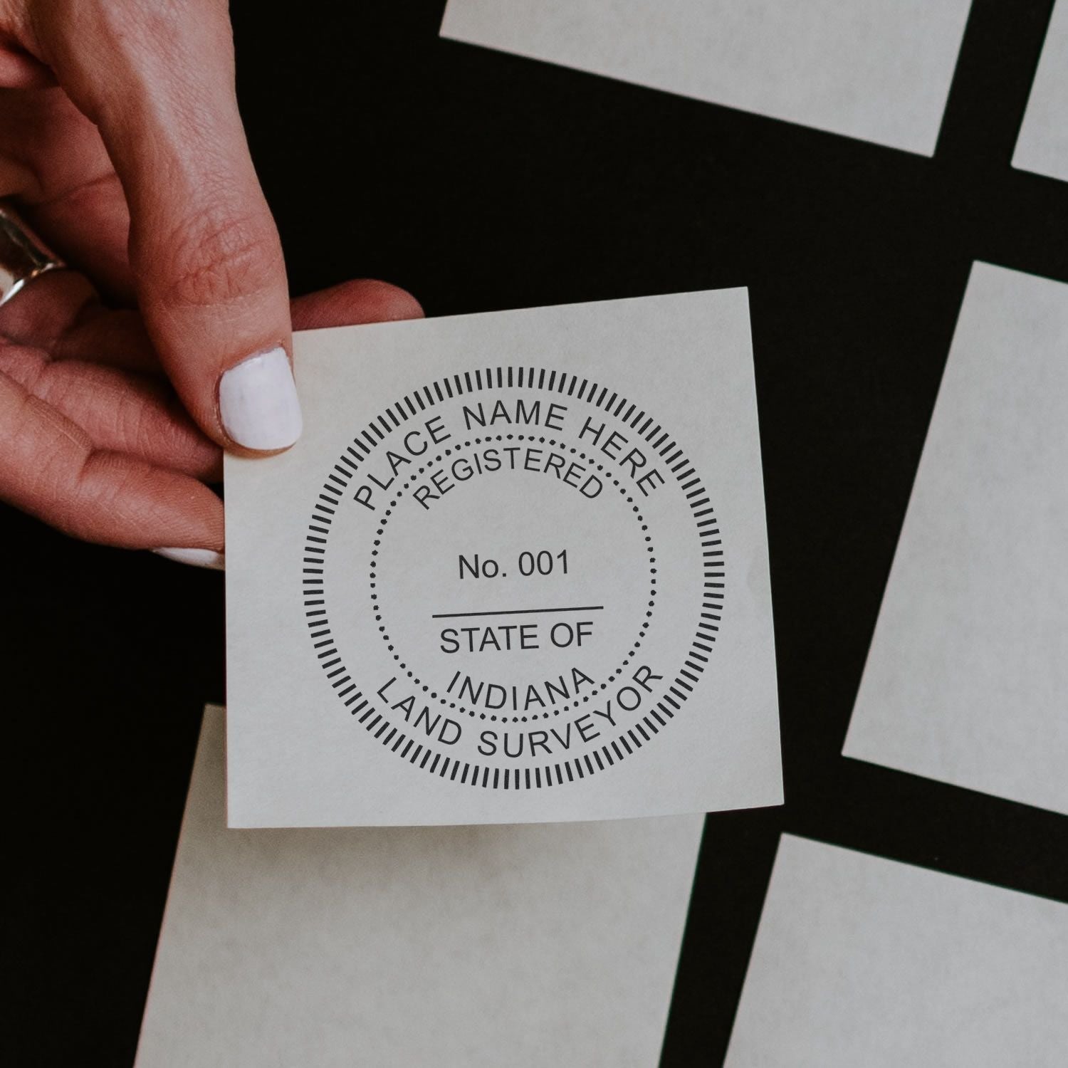 A lifestyle photo showing a stamped image of the Slim Pre-Inked Indiana Land Surveyor Seal Stamp on a piece of paper