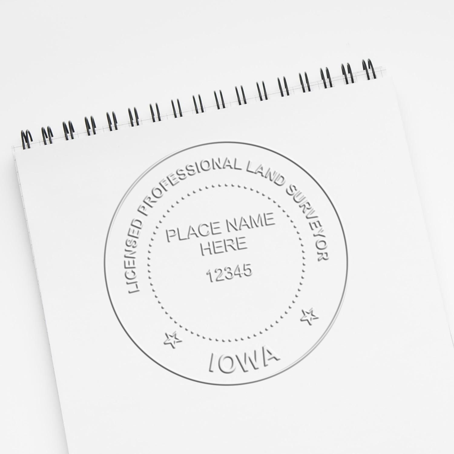 An alternative view of the Handheld Iowa Land Surveyor Seal stamped on a sheet of paper showing the image in use