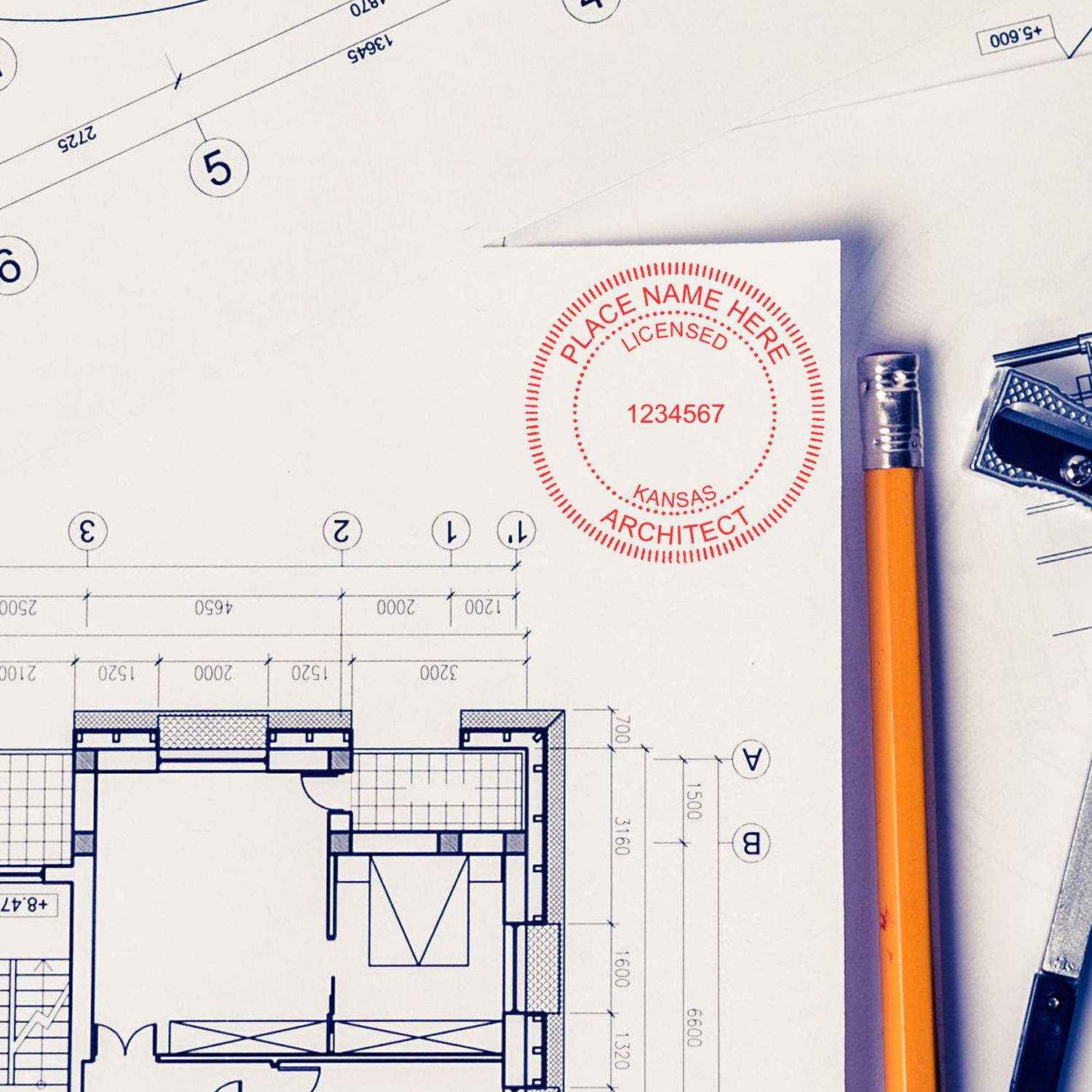 Kansas Architect Seal Stamp on architectural blueprints with a pencil and drafting tools nearby.