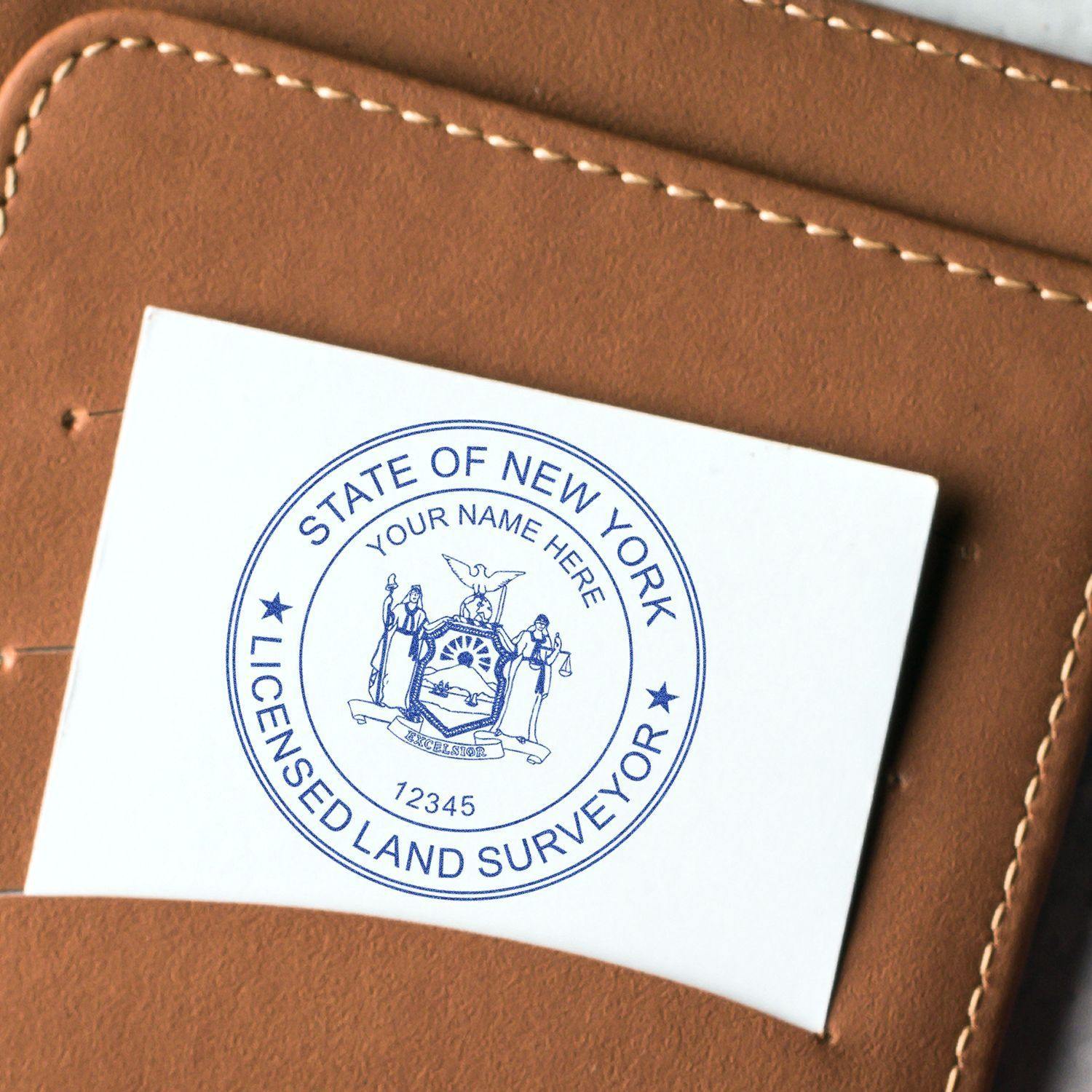 Land Surveyor Self Inking Rubber Stamp of Seal in use, showing a New York licensed land surveyor seal on a white card placed on a brown surface.