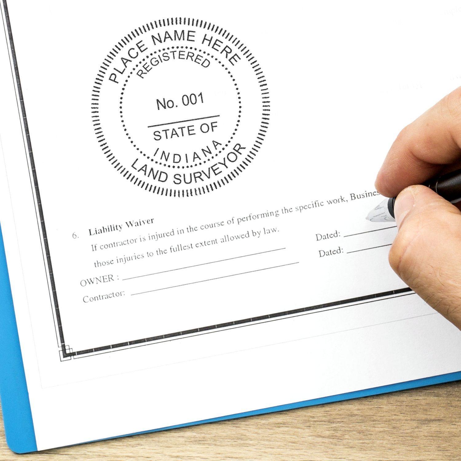 Hand using a pen next to a Land Surveyor eSeal Electronic Image Stamp of Seal on a document with a liability waiver section.