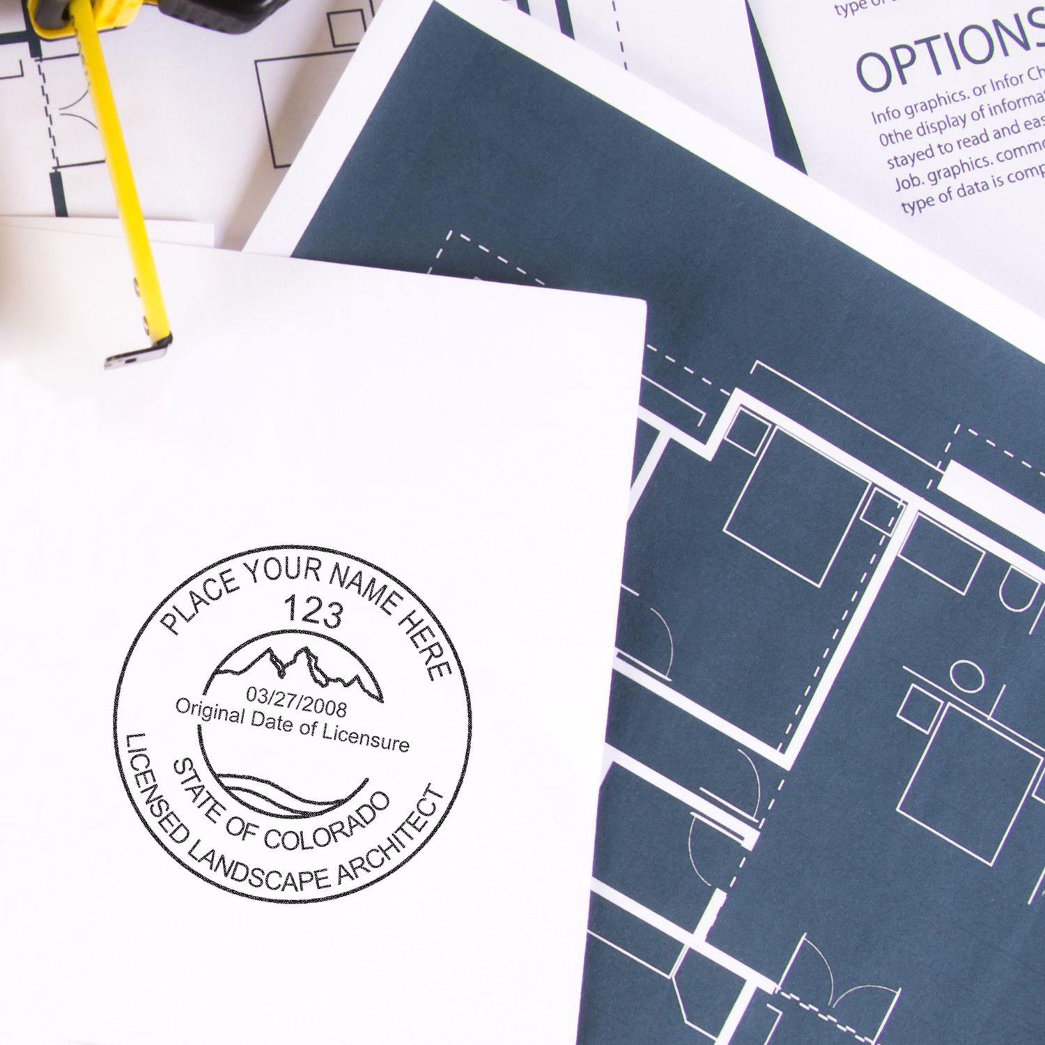 Xstamper Landscape Architect Pre-Inked Rubber Stamp of Seal used on a document, surrounded by architectural blueprints.