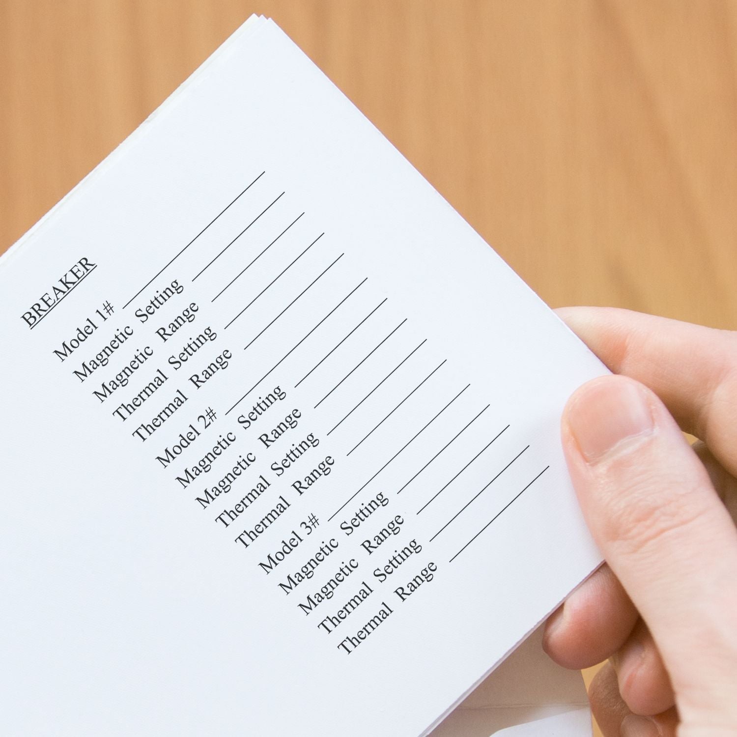 A hand holding a paper stamped with a 15-Line Custom Rubber Stamp with Wood Handle, showing various settings and ranges.