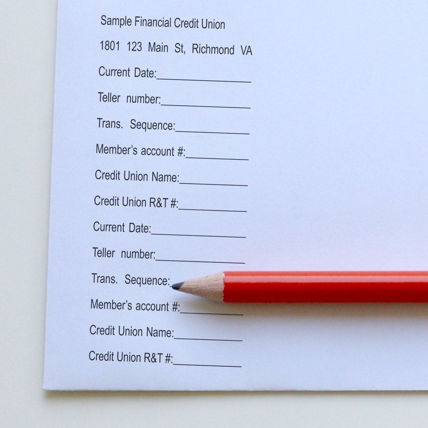 A red pencil rests on a form stamped with a 15-Line Custom Rubber Stamp with Wood Handle, showing various fields for financial information.