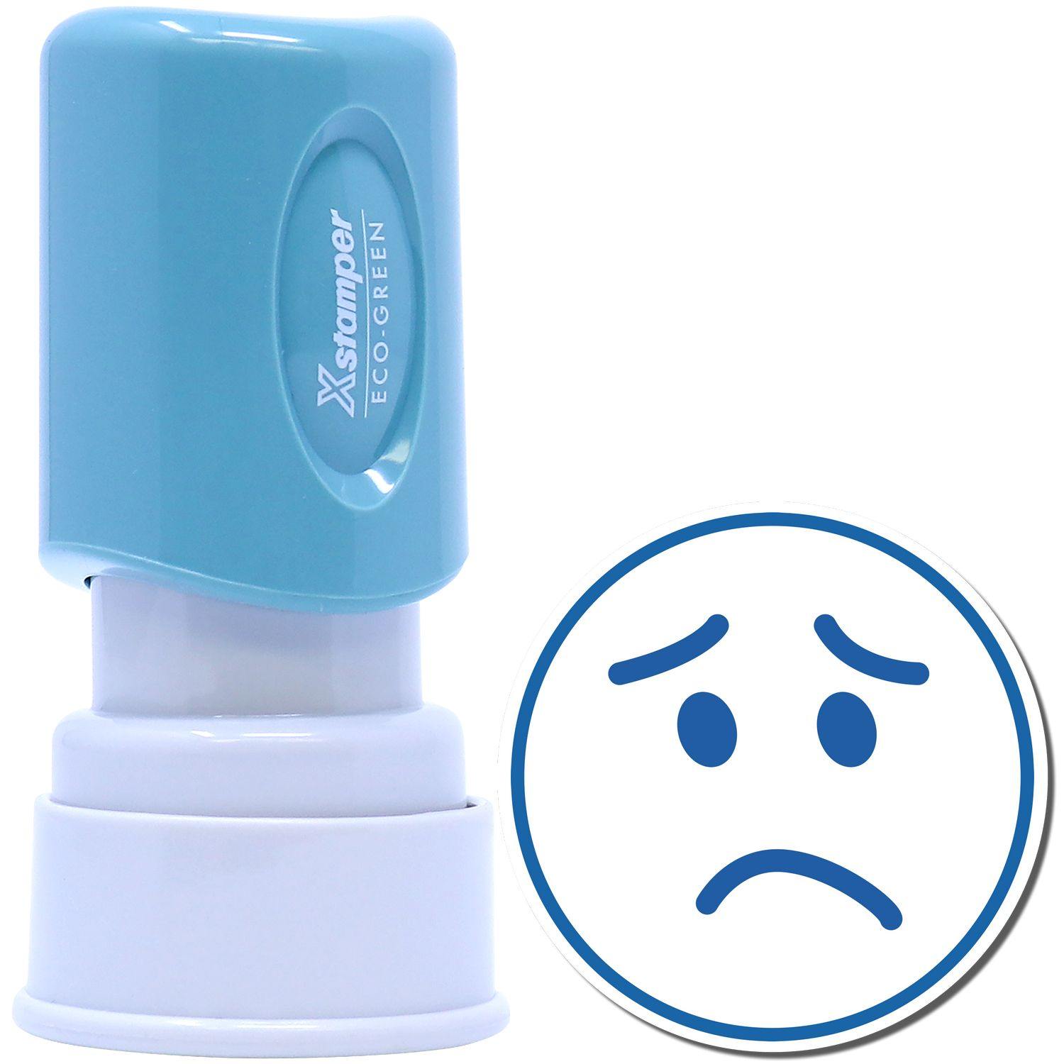 Round Frown Face Xstamper Stamp with a blue handle and a white base, next to a stamped image of a sad face in blue.