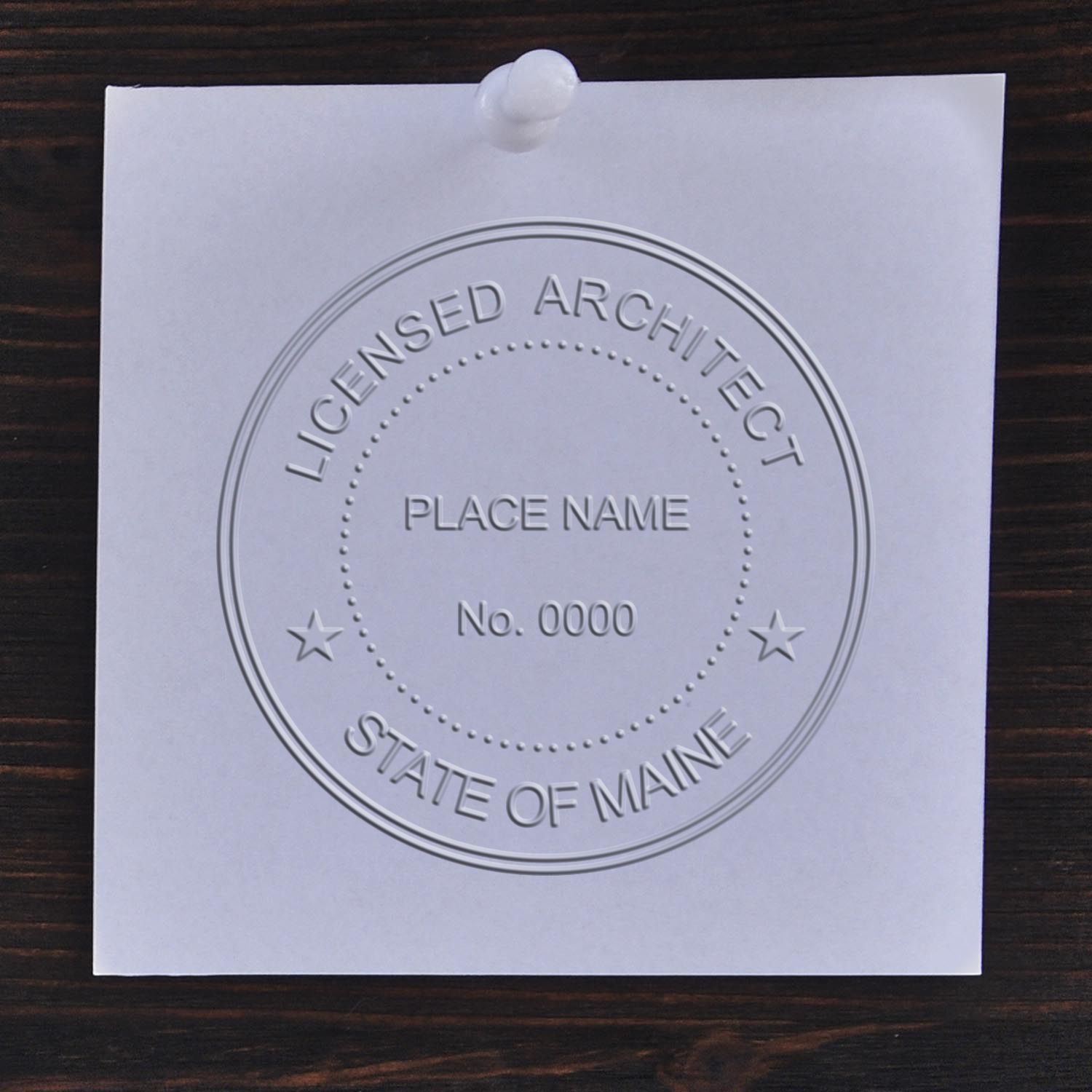 An in use photo of the Hybrid Maine Architect Seal showing a sample imprint on a cardstock