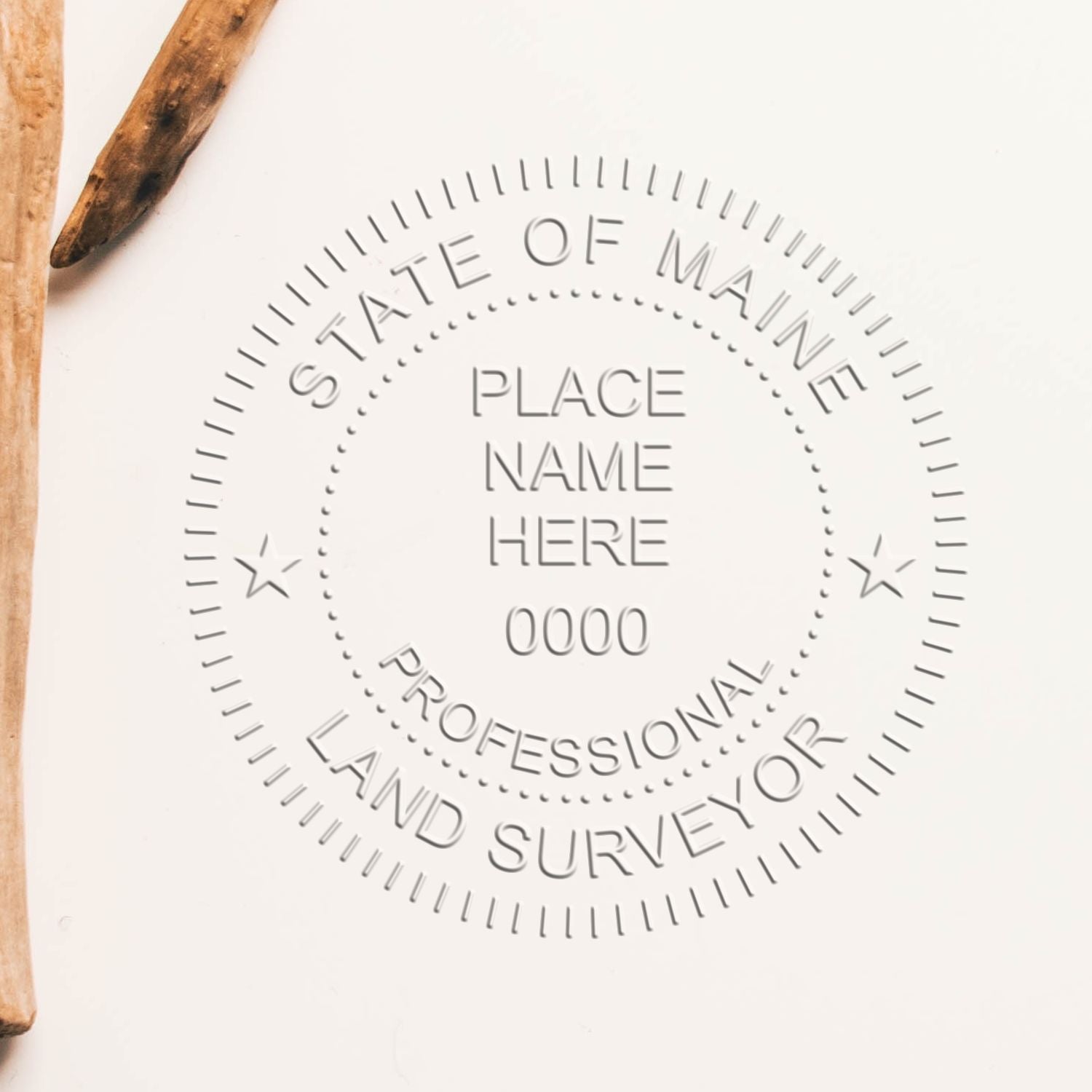 An alternative view of the Heavy Duty Cast Iron Maine Land Surveyor Seal Embosser stamped on a sheet of paper showing the image in use