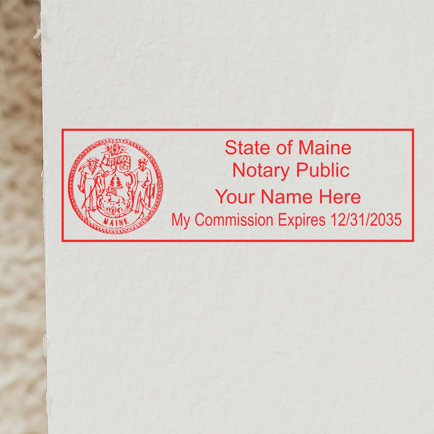 An alternative view of the MaxLight Premium Pre-Inked Maine State Seal Notarial Stamp stamped on a sheet of paper showing the image in use