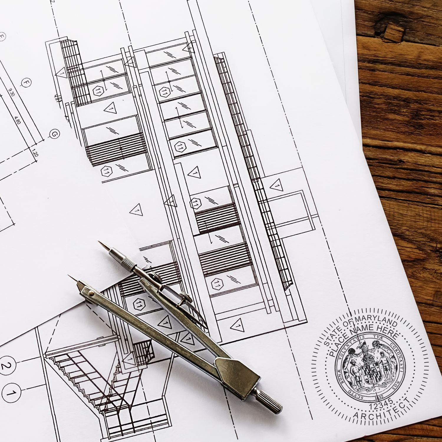 Architectural blueprint with a Self Inking Maryland Architect Stamp impression and a compass placed on top.