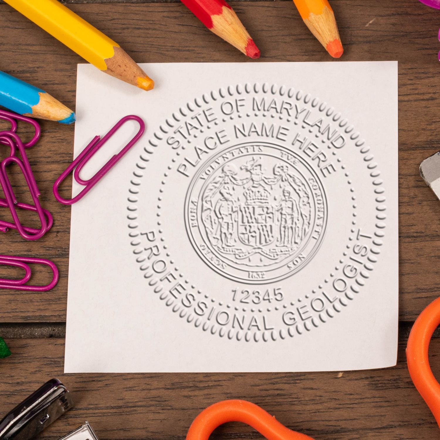 A lifestyle photo showing a stamped image of the Heavy Duty Cast Iron Maryland Geologist Seal Embosser on a piece of paper