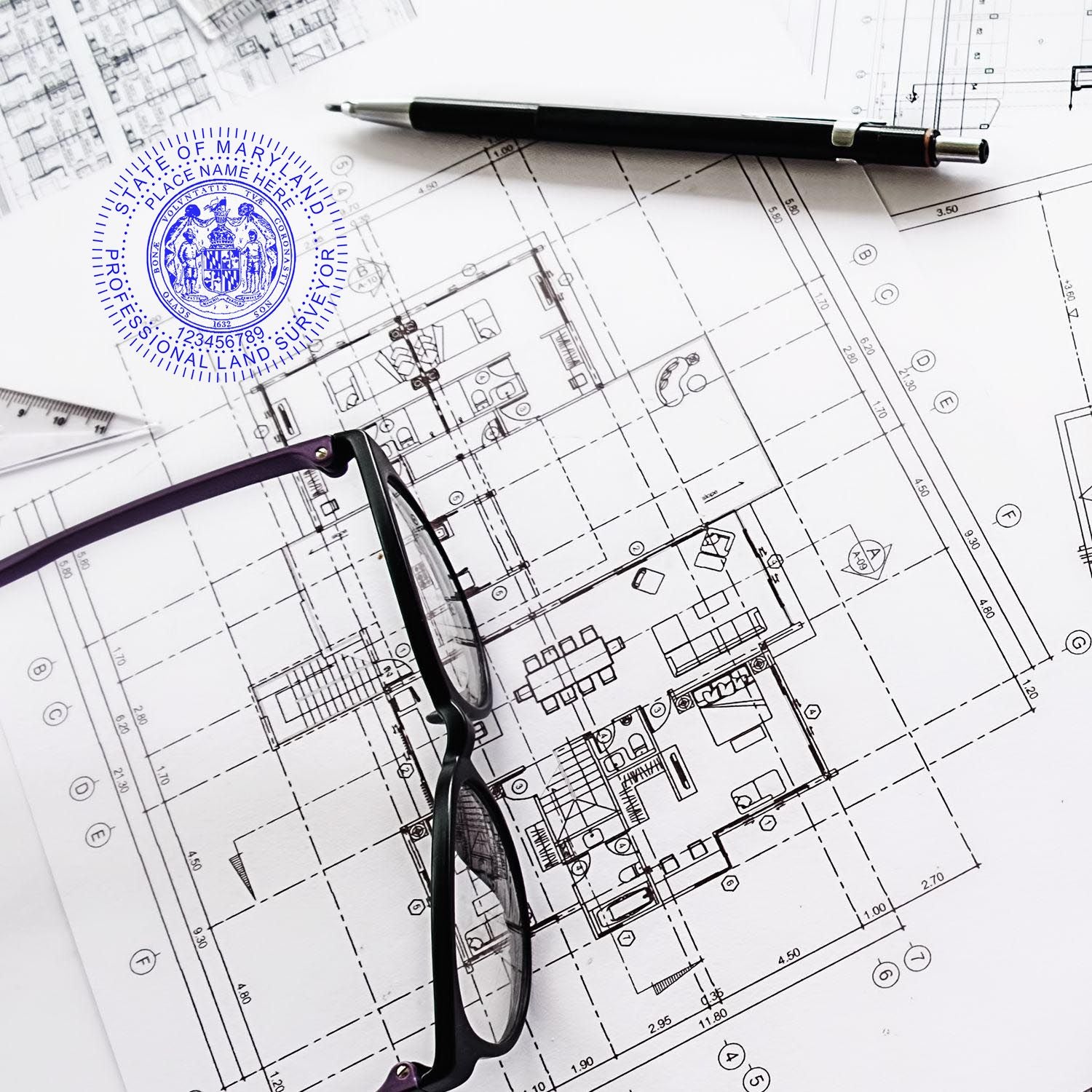 Maryland Land Surveyor Seal Stamp, MD PLS Stamp on architectural blueprints with a pen and glasses nearby.