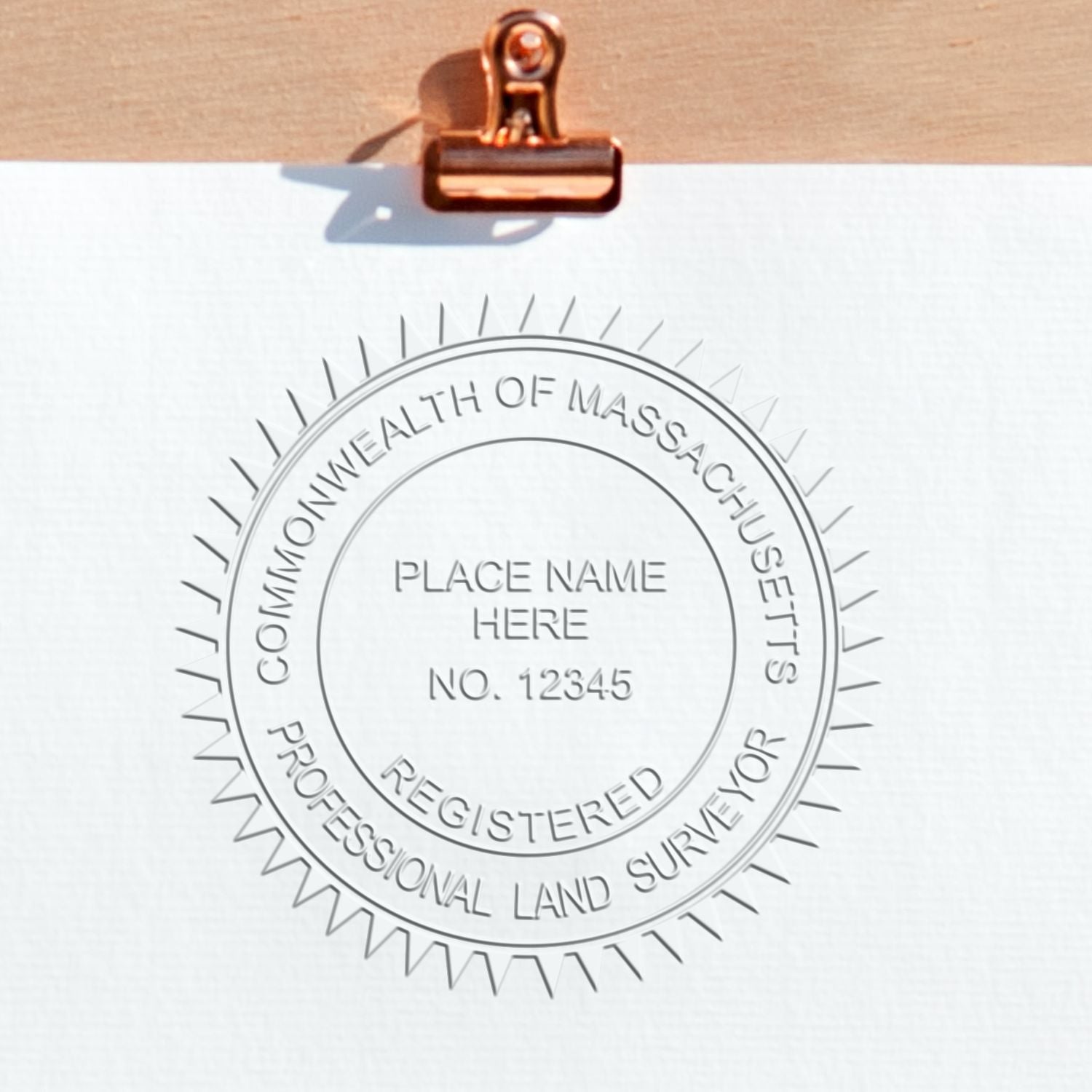 An alternative view of the Heavy Duty Cast Iron Massachusetts Land Surveyor Seal Embosser stamped on a sheet of paper showing the image in use