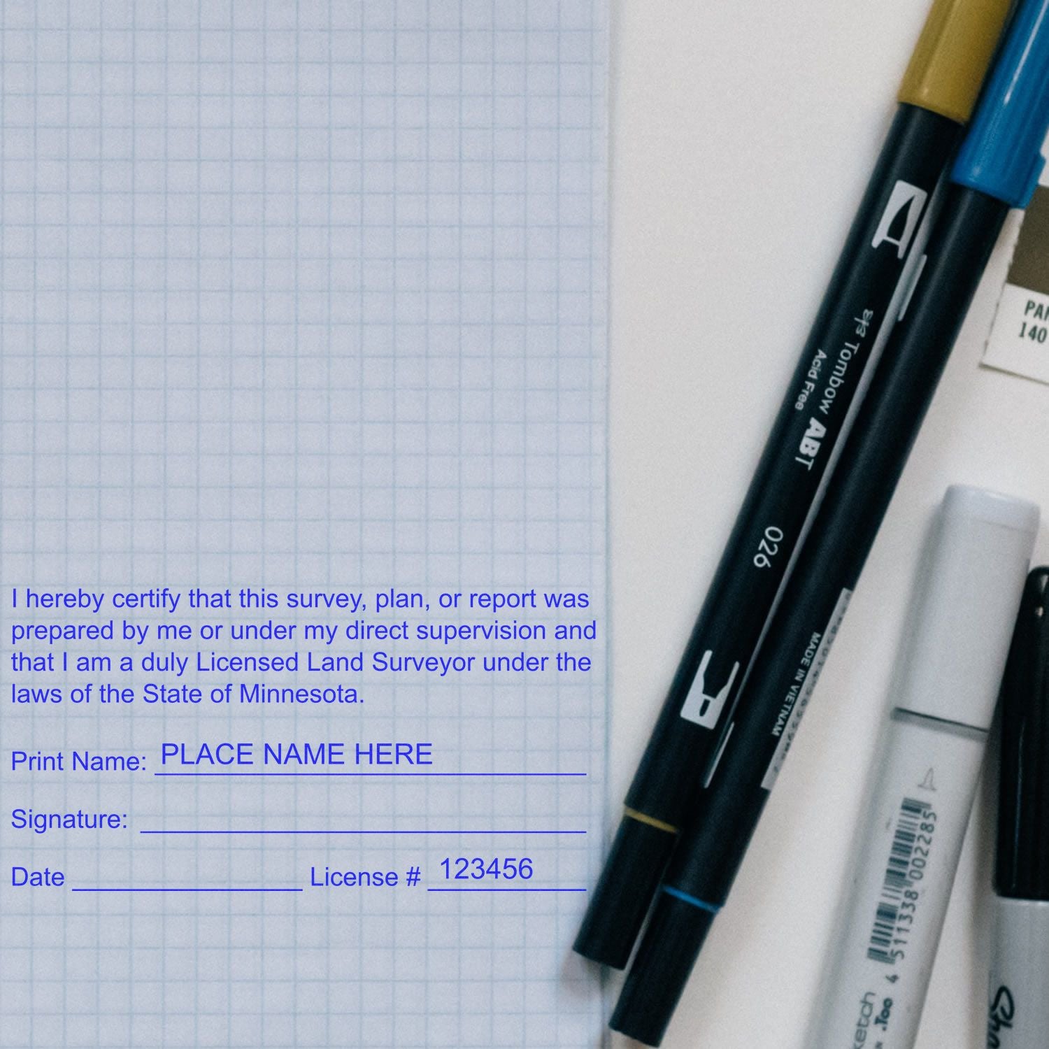 Digital Minnesota Land Surveyor Stamp, Electronic Seal for Minnesota Land Surveyor, displayed on a graph paper with pens and markers nearby.