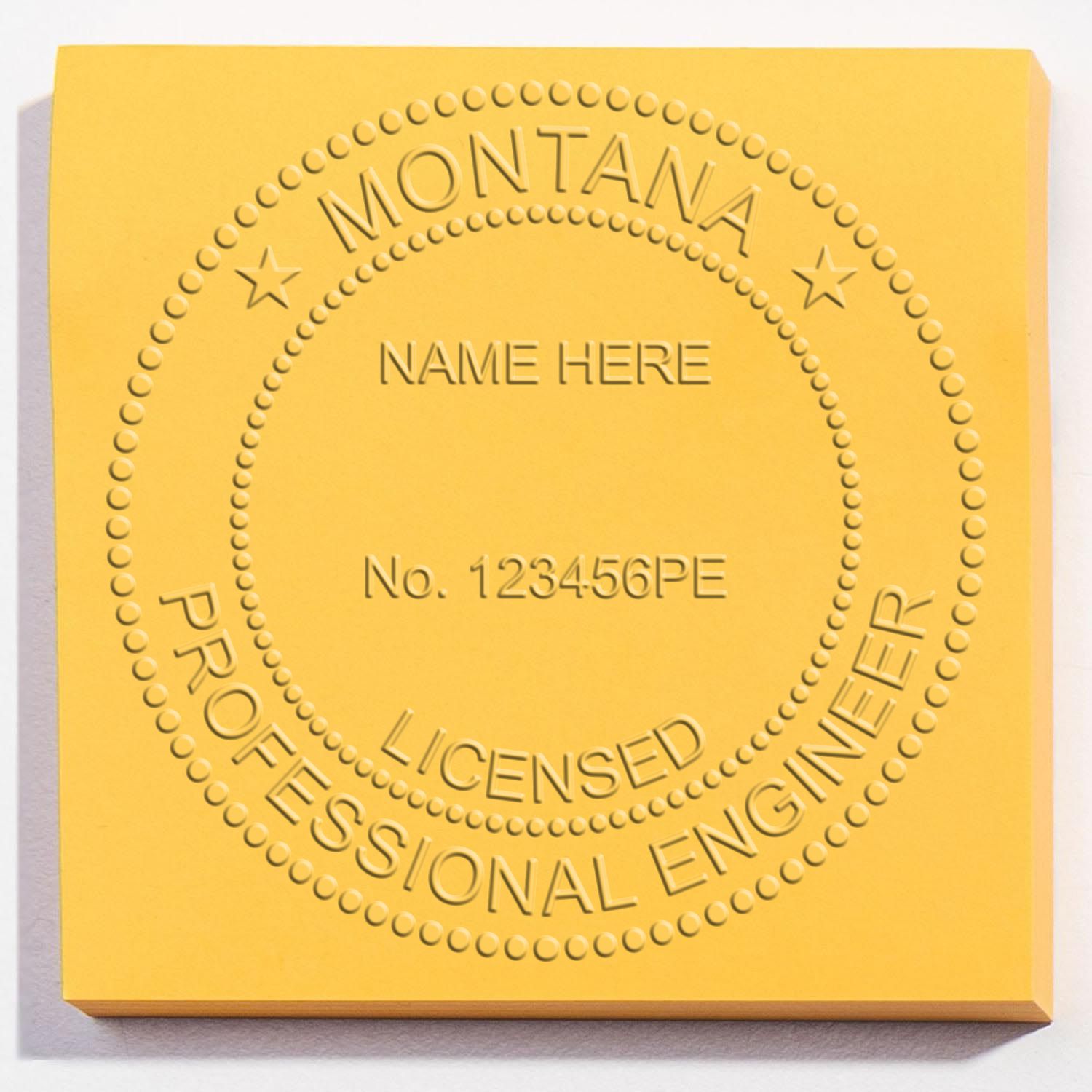 A lifestyle photo showing a stamped image of the Handheld Montana Professional Engineer Embosser on a piece of paper
