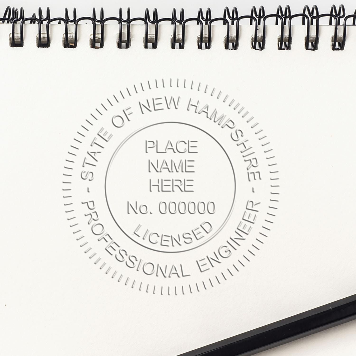 An in use photo of the Hybrid New Hampshire Engineer Seal showing a sample imprint on a cardstock