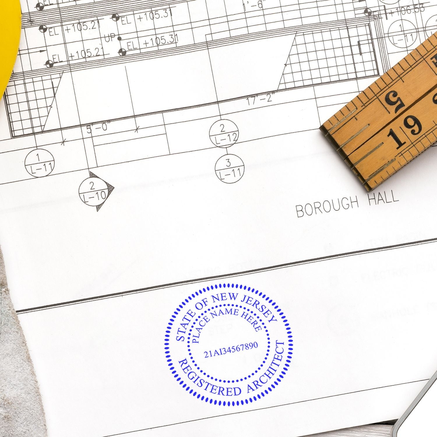 Premium MaxLight Pre-Inked New Jersey Architectural Stamp in blue ink on architectural plans with a ruler and yellow pen nearby.