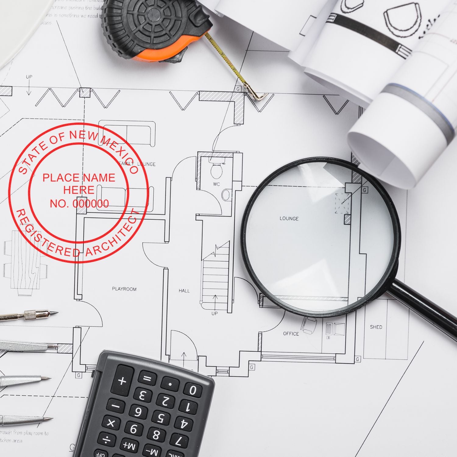 New Mexico Architect Seal Stamp on architectural blueprints with a magnifying glass, calculator, and drafting tools.