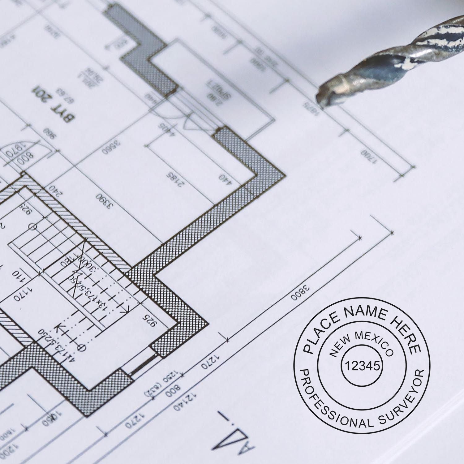 Self Inking New Mexico Land Surveyor Stamp in use on architectural blueprint, displaying professional surveyor seal and details.