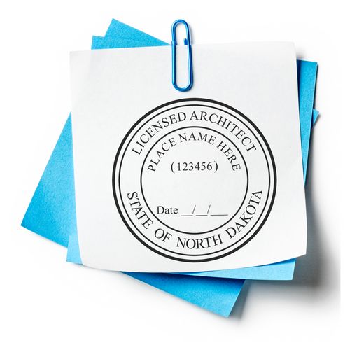 Premium MaxLight Pre-Inked North Dakota Architectural Stamp on white paper with blue sheets and a paperclip.