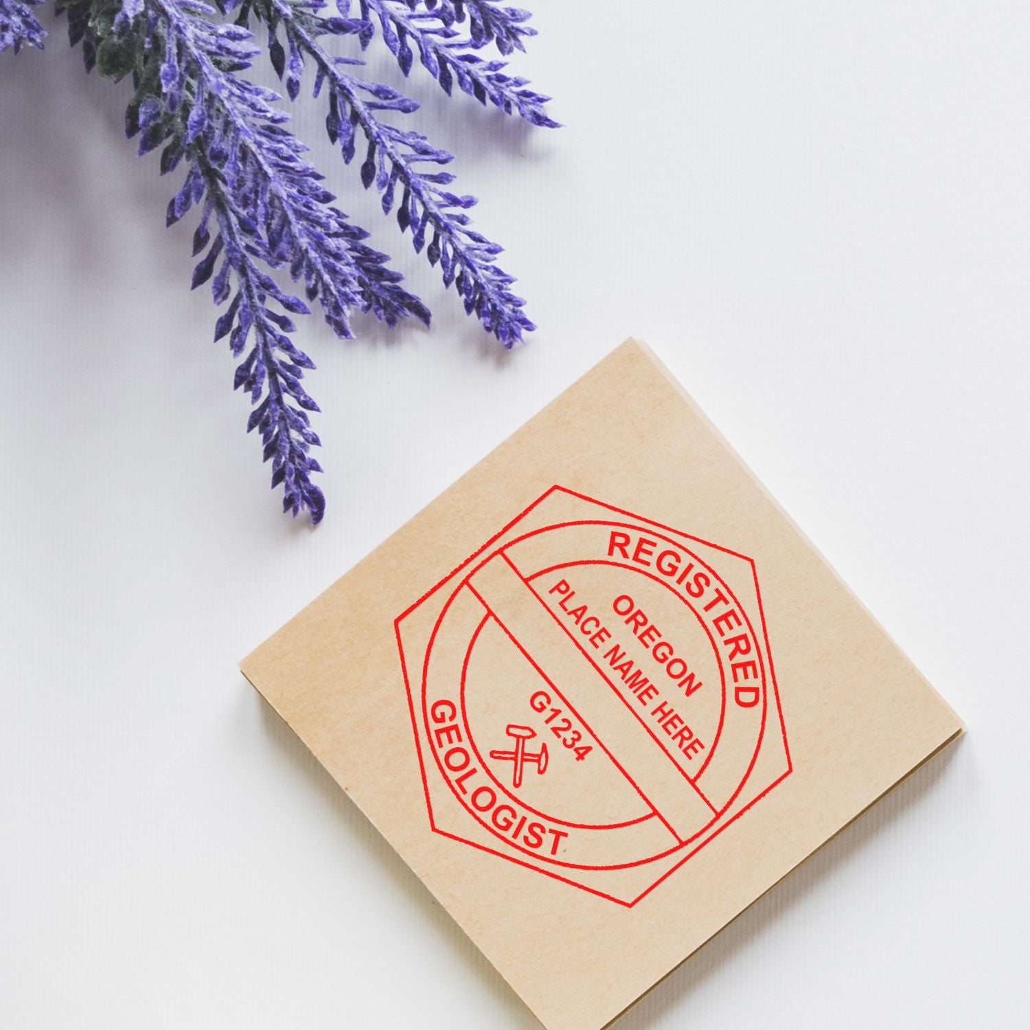 An in use photo of the Oregon Professional Geologist Seal Stamp showing a sample imprint on a cardstock