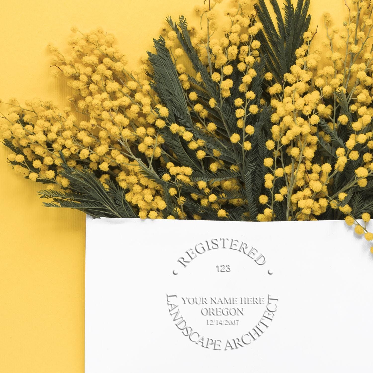 An in use photo of the Gift Oregon Landscape Architect Seal showing a sample imprint on a cardstock