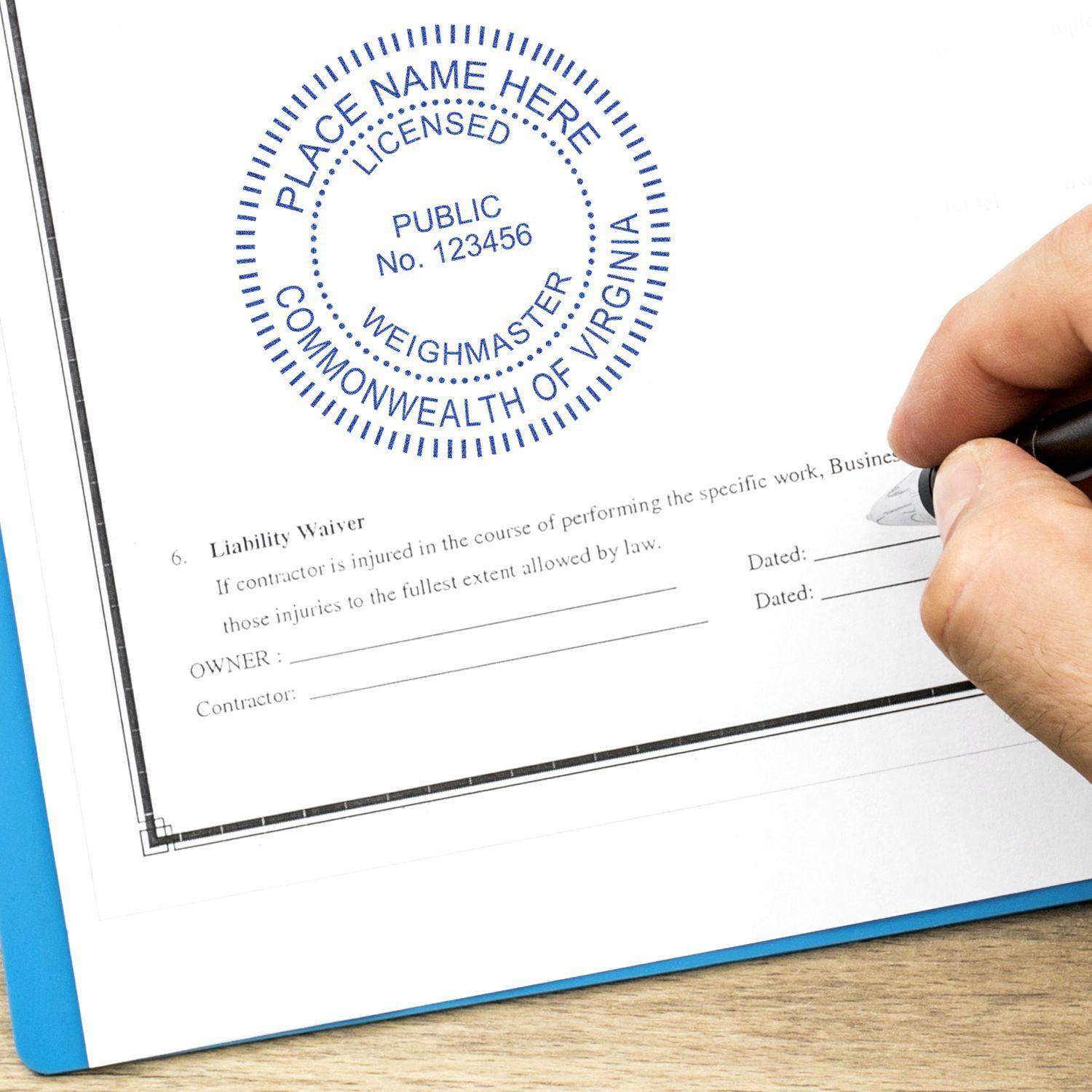 A hand using a pen to sign a document stamped with the Public Weighmaster eSeal Electronic Image Stamp of Seal, showing a blue circular seal.