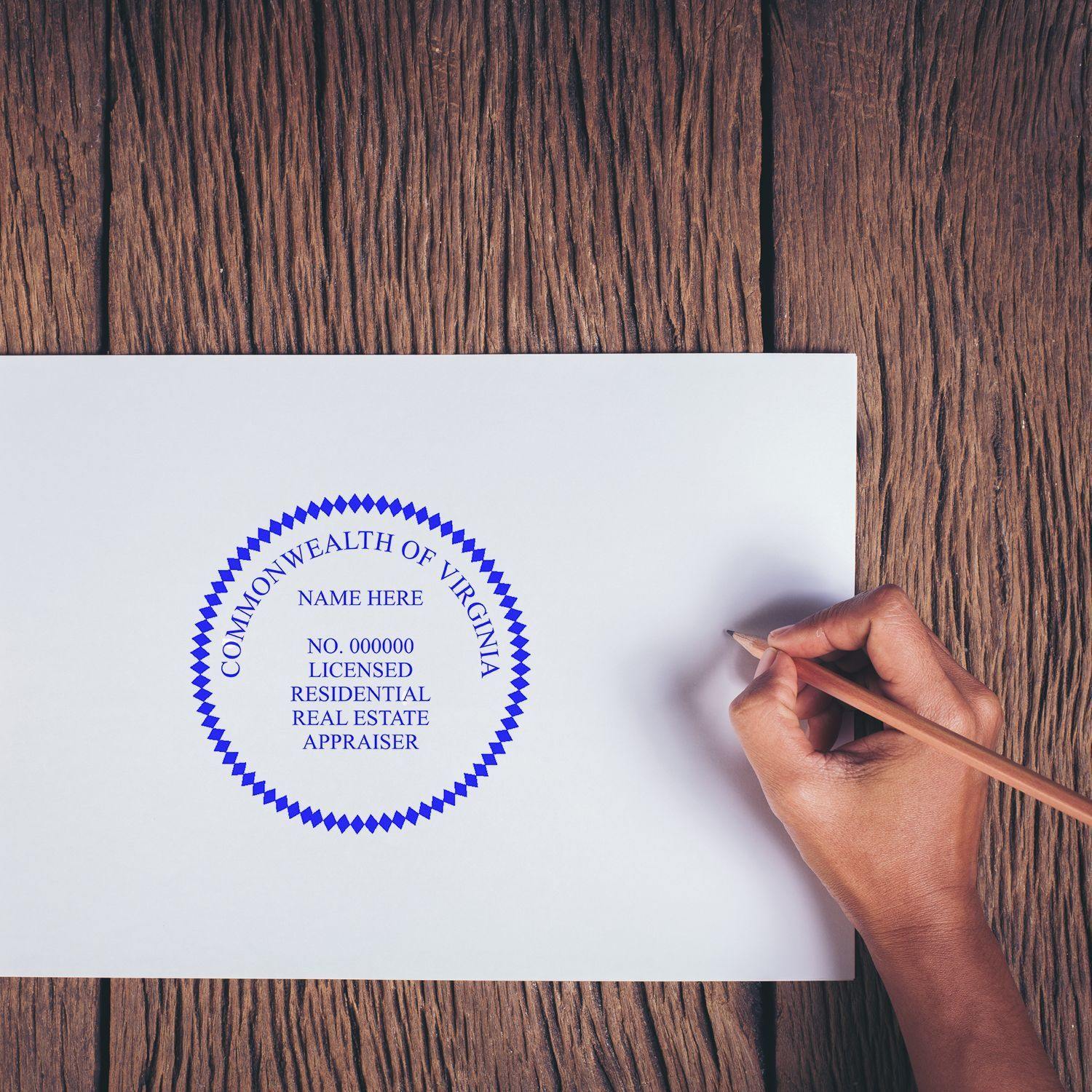 Person using the Real Estate Appraiser Slim Pre Inked Rubber Stamp of Seal on a document, featuring a blue seal with text.