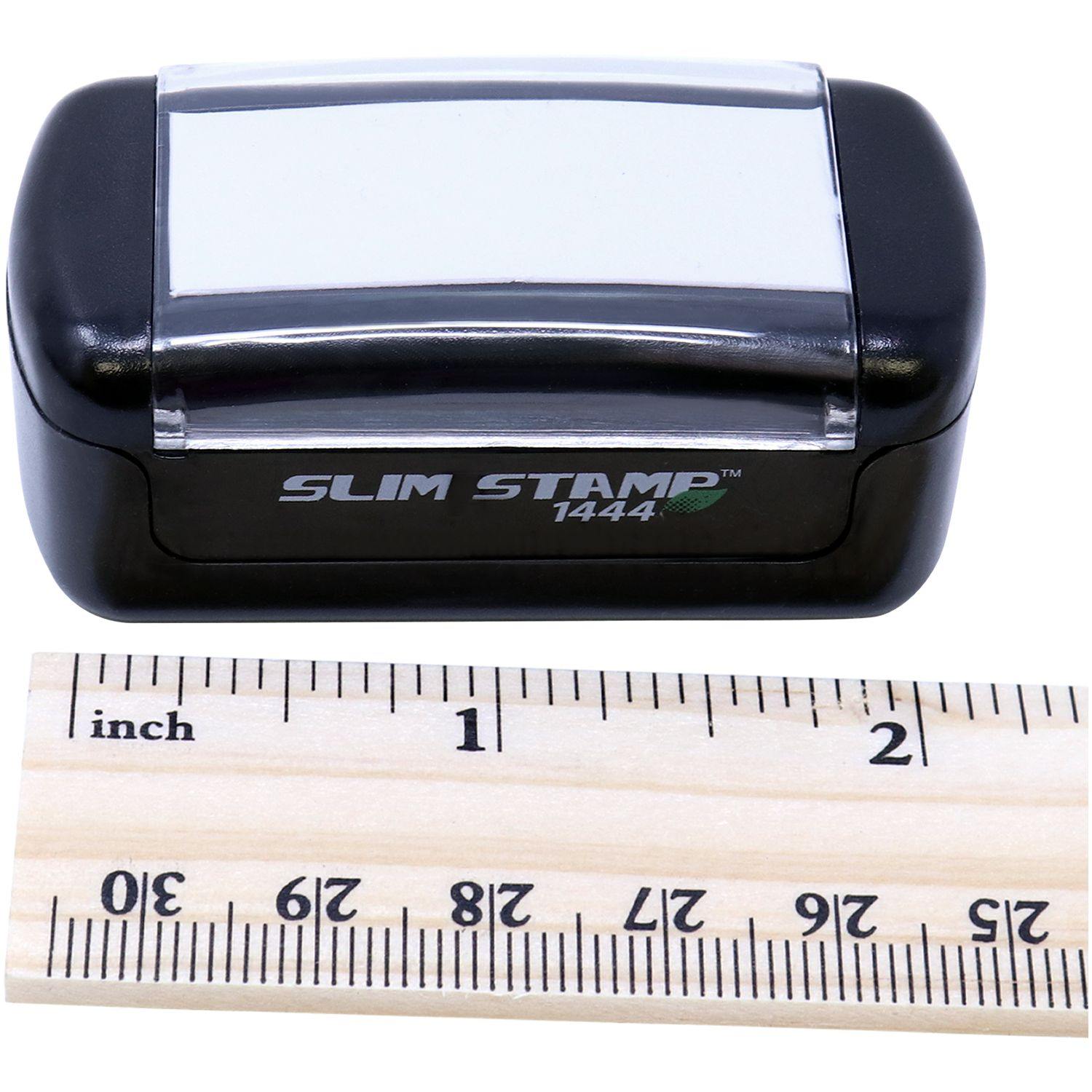 Slim Pre-Inked Deposition Exhibit Stamp next to a wooden ruler showing measurements in inches and centimeters.