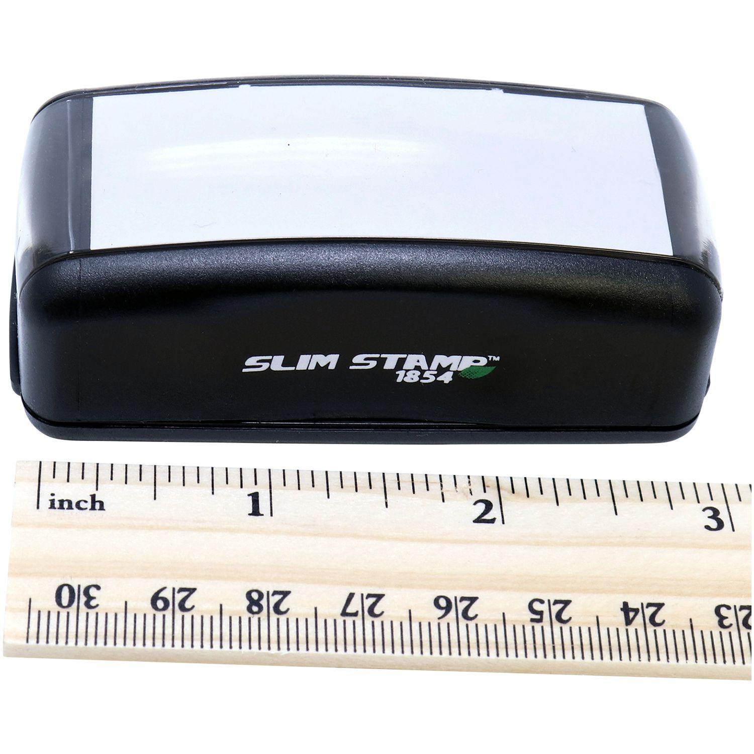 Large Pre-Inked Extra Credit Stamp, black with a white label, next to a ruler showing its compact size.