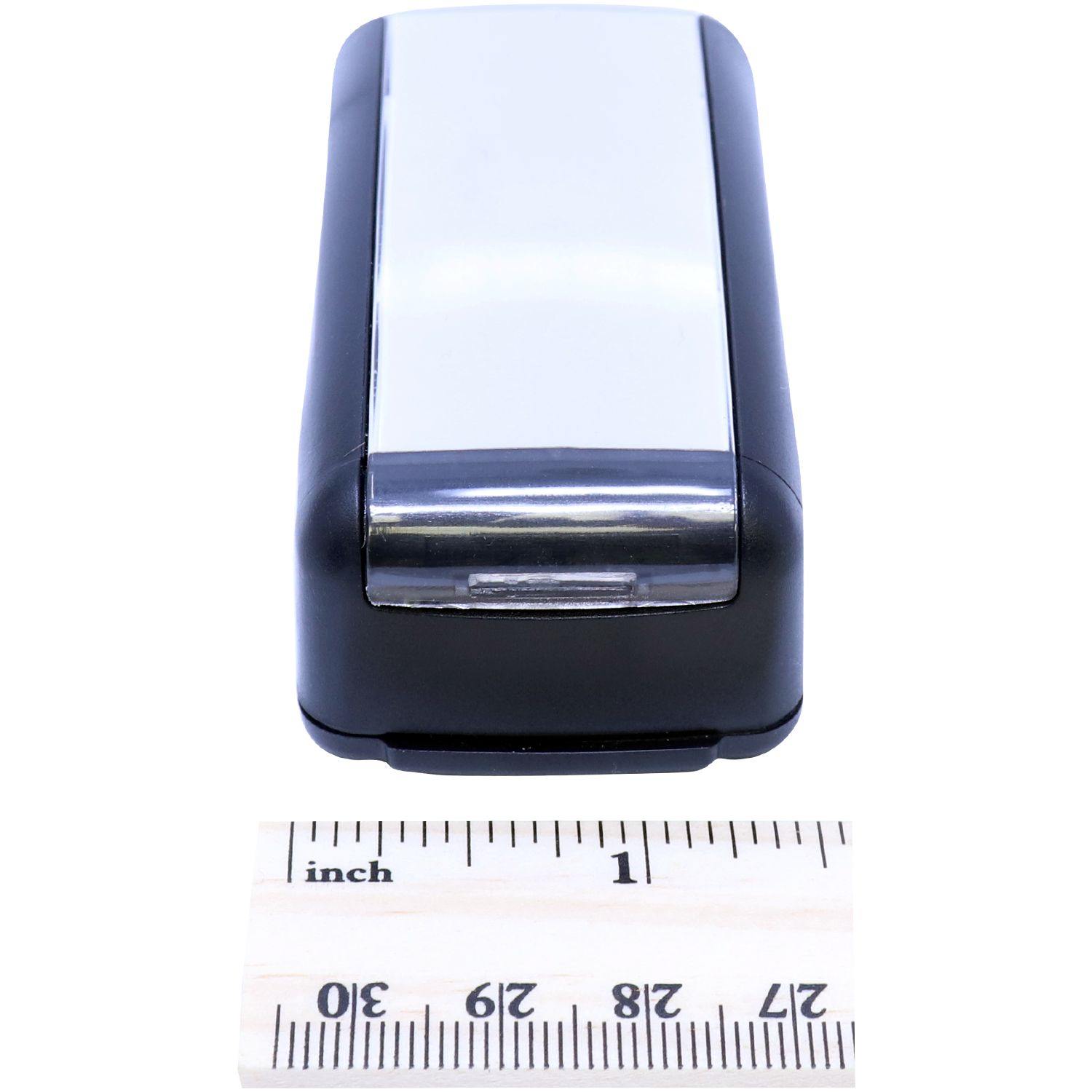 Slim Pre-Inked Issued for Construction Stamp next to a ruler showing its compact size.