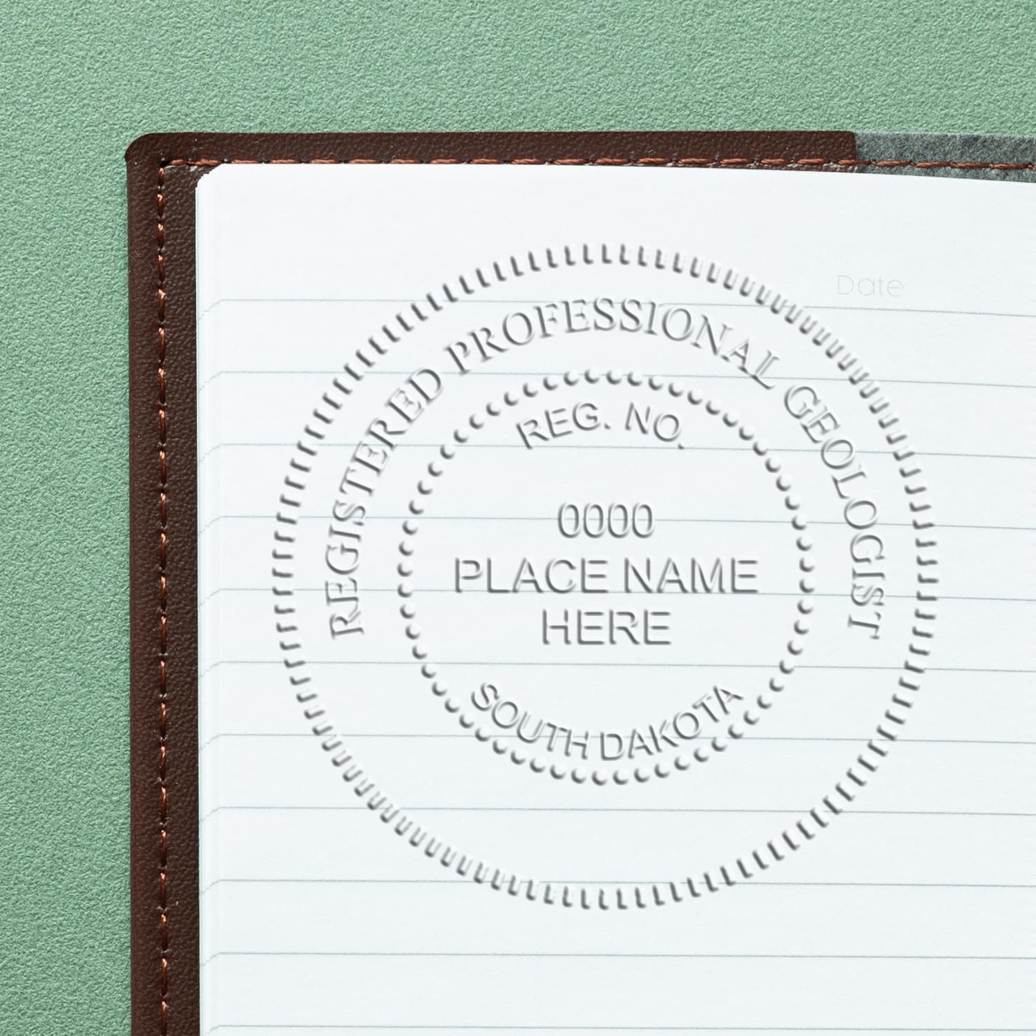 An in use photo of the South Dakota Geologist Desk Seal showing a sample imprint on a cardstock