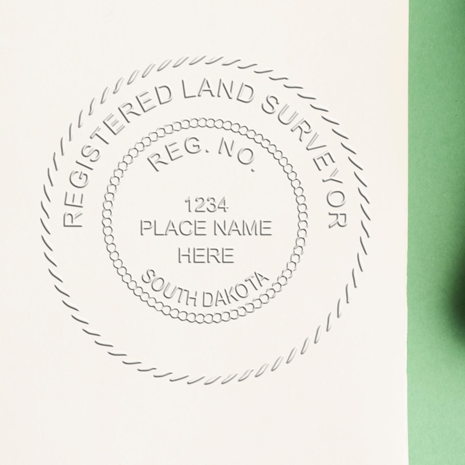 A lifestyle photo showing a stamped image of the Handheld South Dakota Land Surveyor Seal on a piece of paper