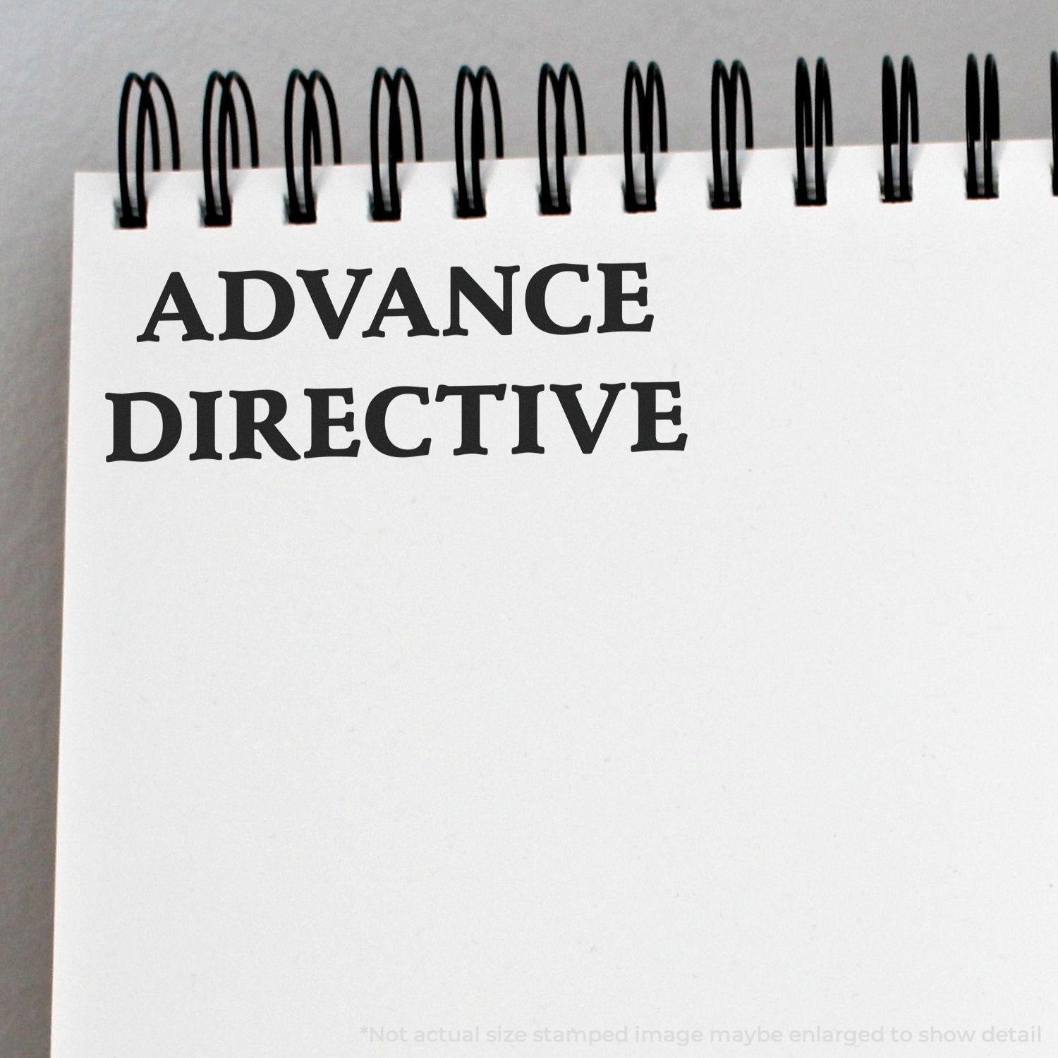 Self Inking Advance Directive Stamp imprint on a spiral-bound notebook, showing clear and bold text ADVANCE DIRECTIVE in black ink.