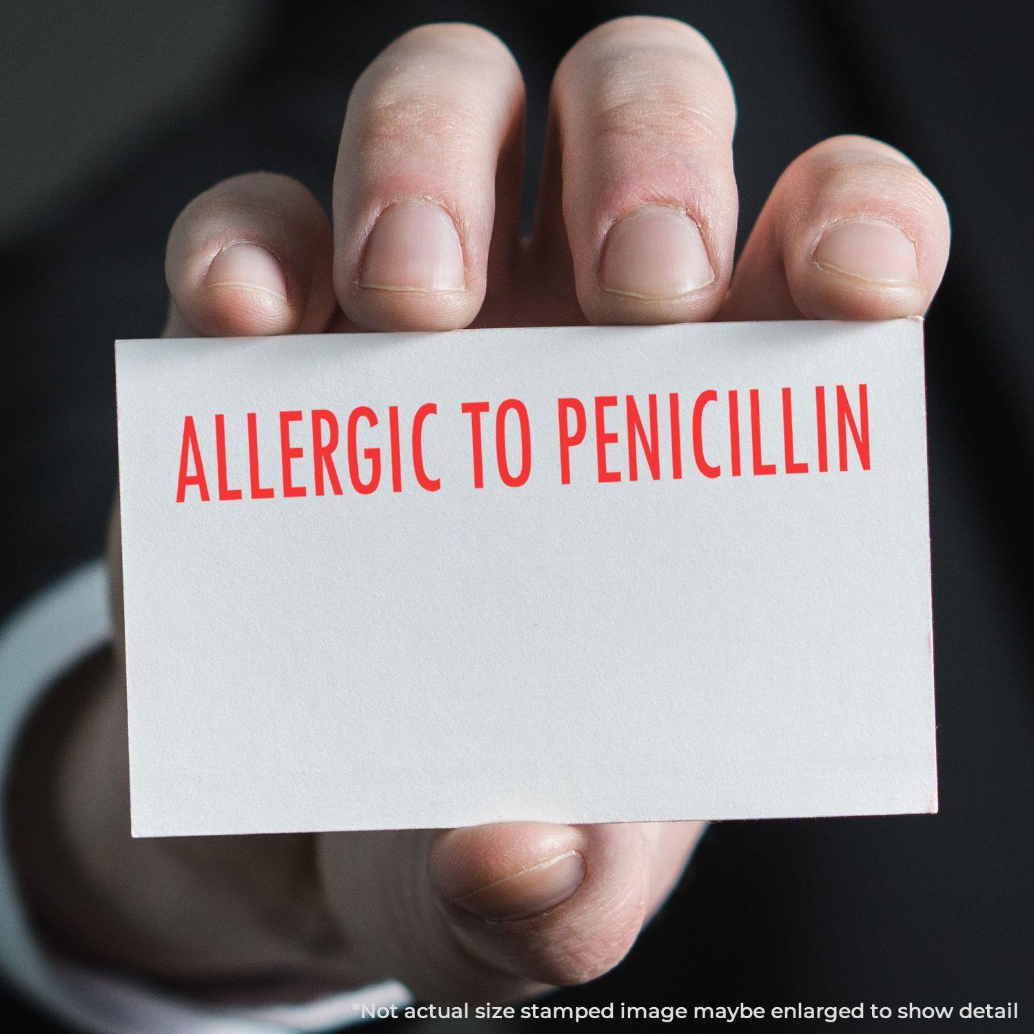 Person holding a card stamped with Allergic To Penicillin in red ink using the Large Pre-Inked Allergic To Penicillin Stamp.