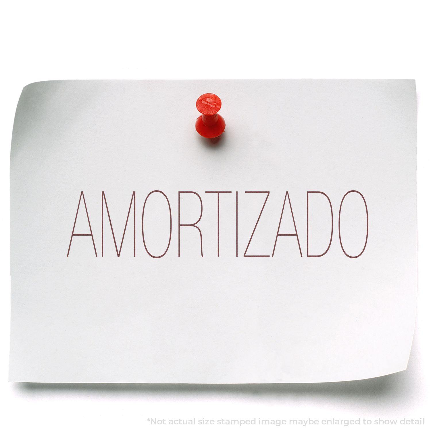 A white paper with AMORTIZADO stamped in red using the Large Amortizado Rubber Stamp, pinned to a surface with a red pushpin.