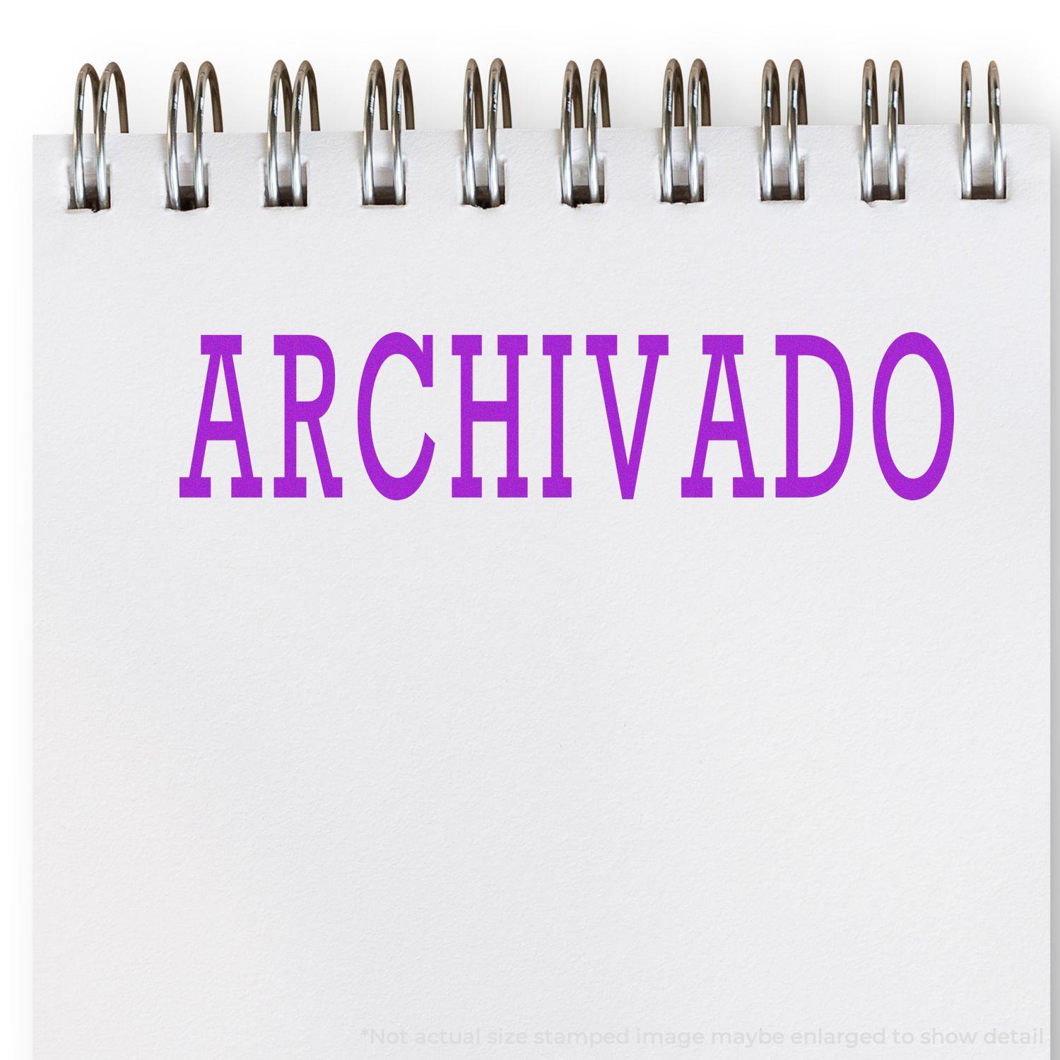 Large Archivado Rubber Stamp in use, showing the word "ARCHIVADO" stamped in purple on a white notepad with a spiral binding.