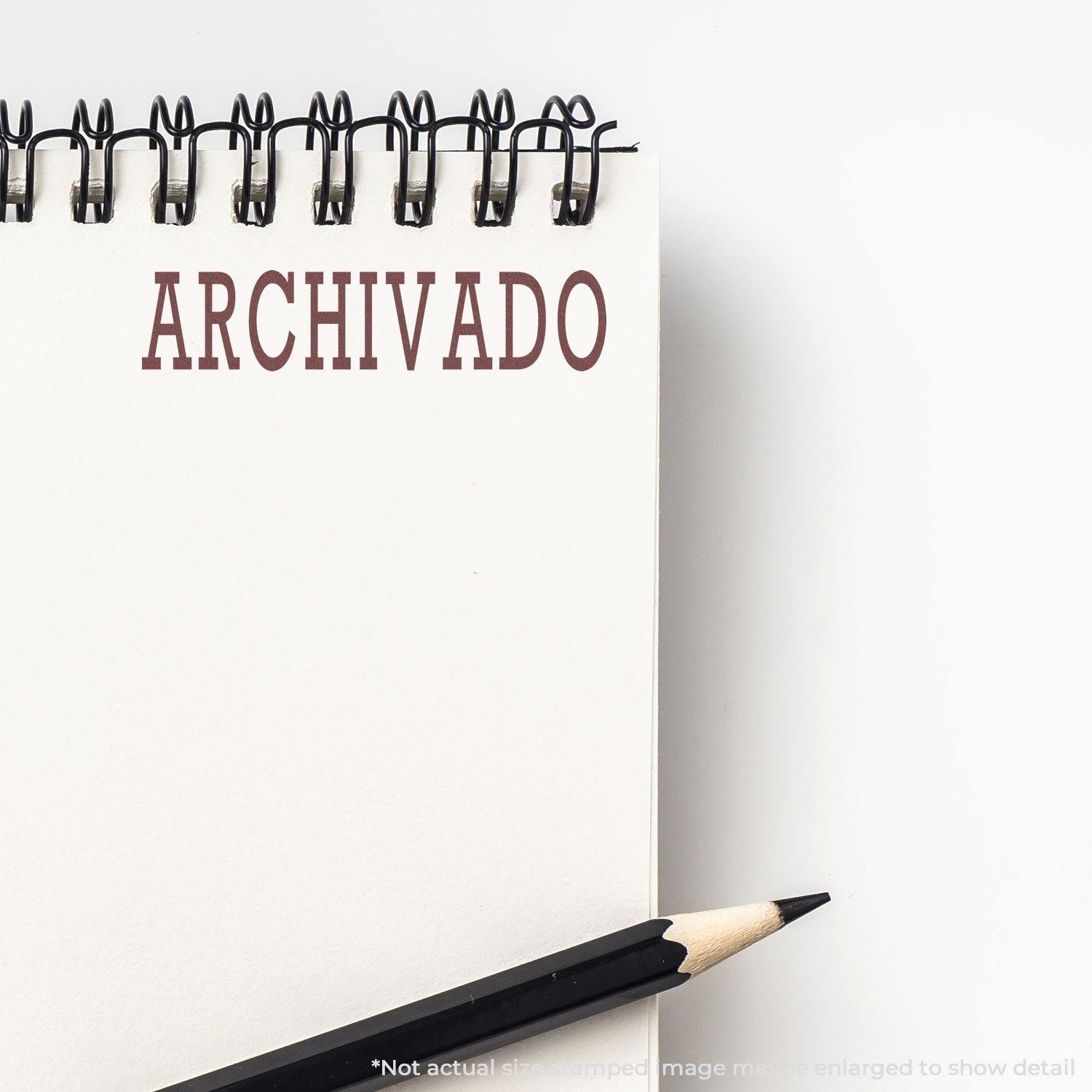 Notebook with the word 'ARCHIVADO' stamped in red using an Archivado Rubber Stamp, with a pencil placed beside it.