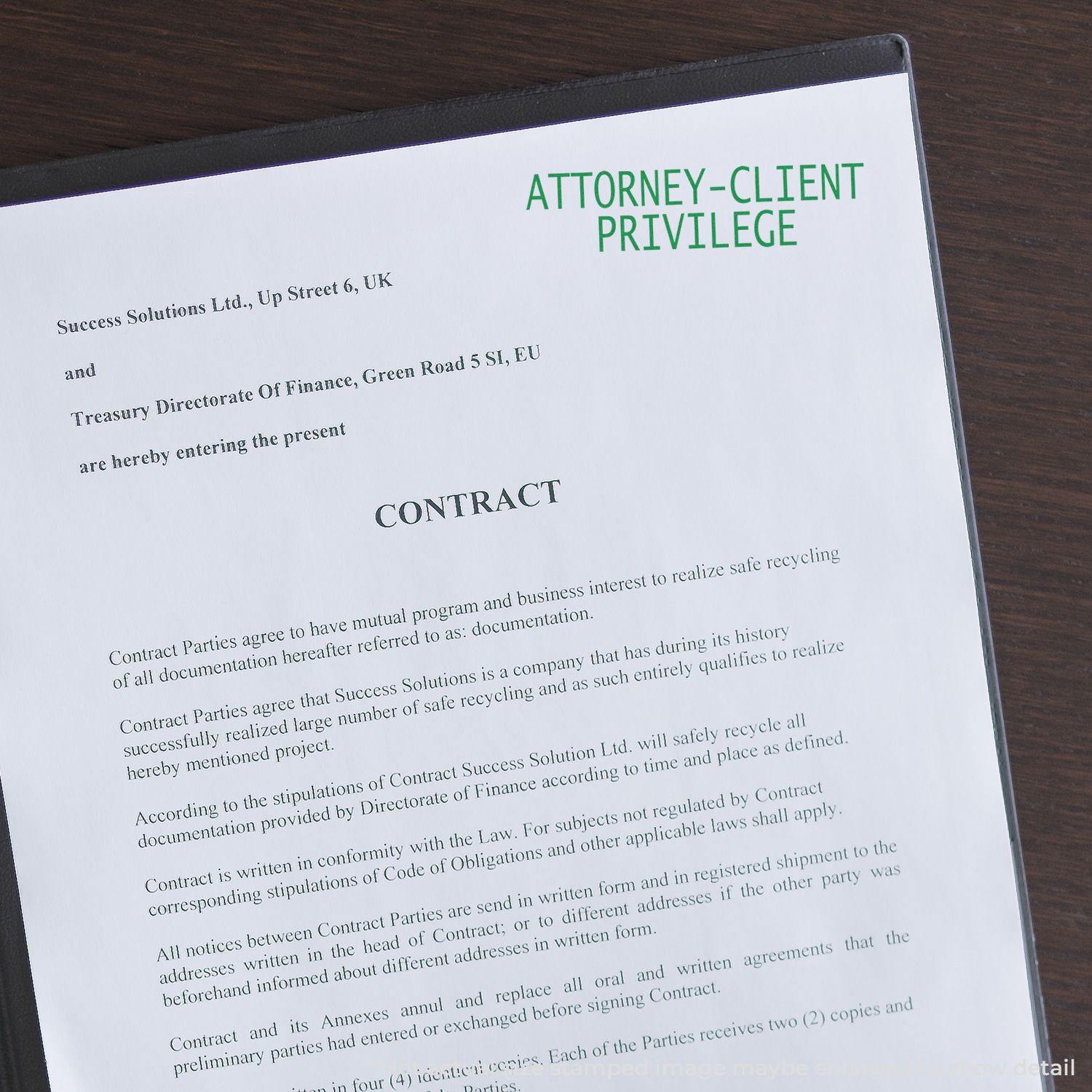 A Large Attorney Client Privilege Rubber Stamp marks a contract document with green ink, emphasizing confidentiality and legal protection.