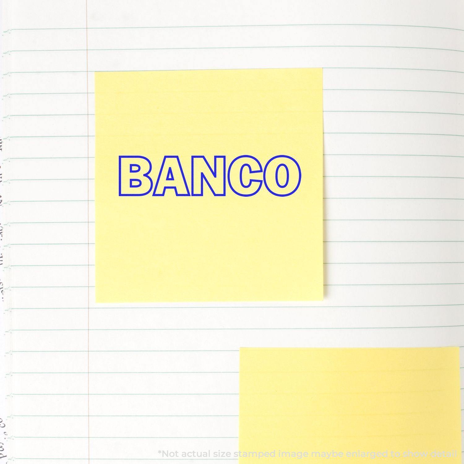 Yellow sticky note stamped with BANCO in blue ink from a Banco Rubber Stamp, placed on a lined notebook page.