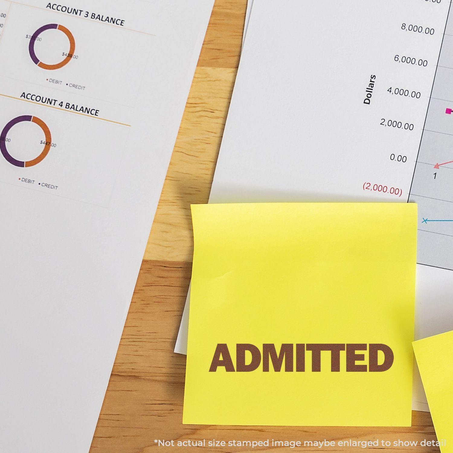 Large Self Inking Bold Admitted Stamp used on a yellow sticky note, placed on a desk with financial documents and charts.