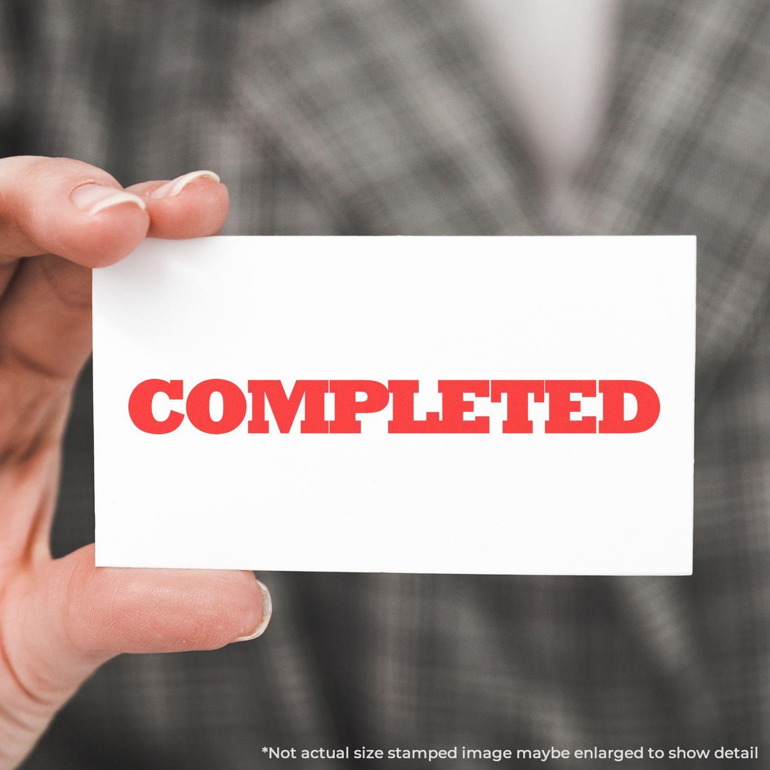 Person holding a card stamped with COMPLETED in red ink using the Large Pre-Inked Bold Completed Stamp.