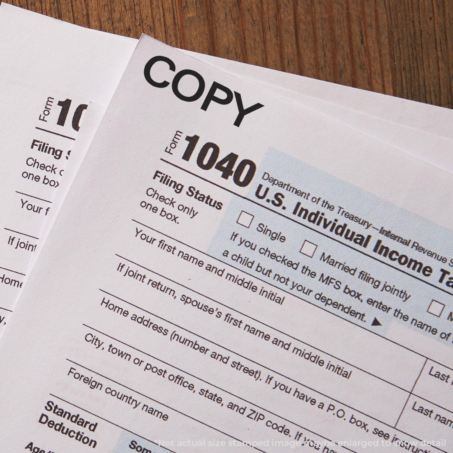 Bold Copy Rubber Stamp marking COPY on U.S. Individual Income Tax Return Form 1040 papers placed on a wooden surface.