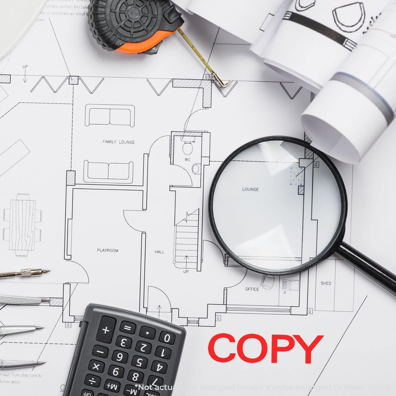 A Large Bold Copy Rubber Stamp marks COPY in red on architectural plans, surrounded by a magnifying glass, calculator, and drafting tools.