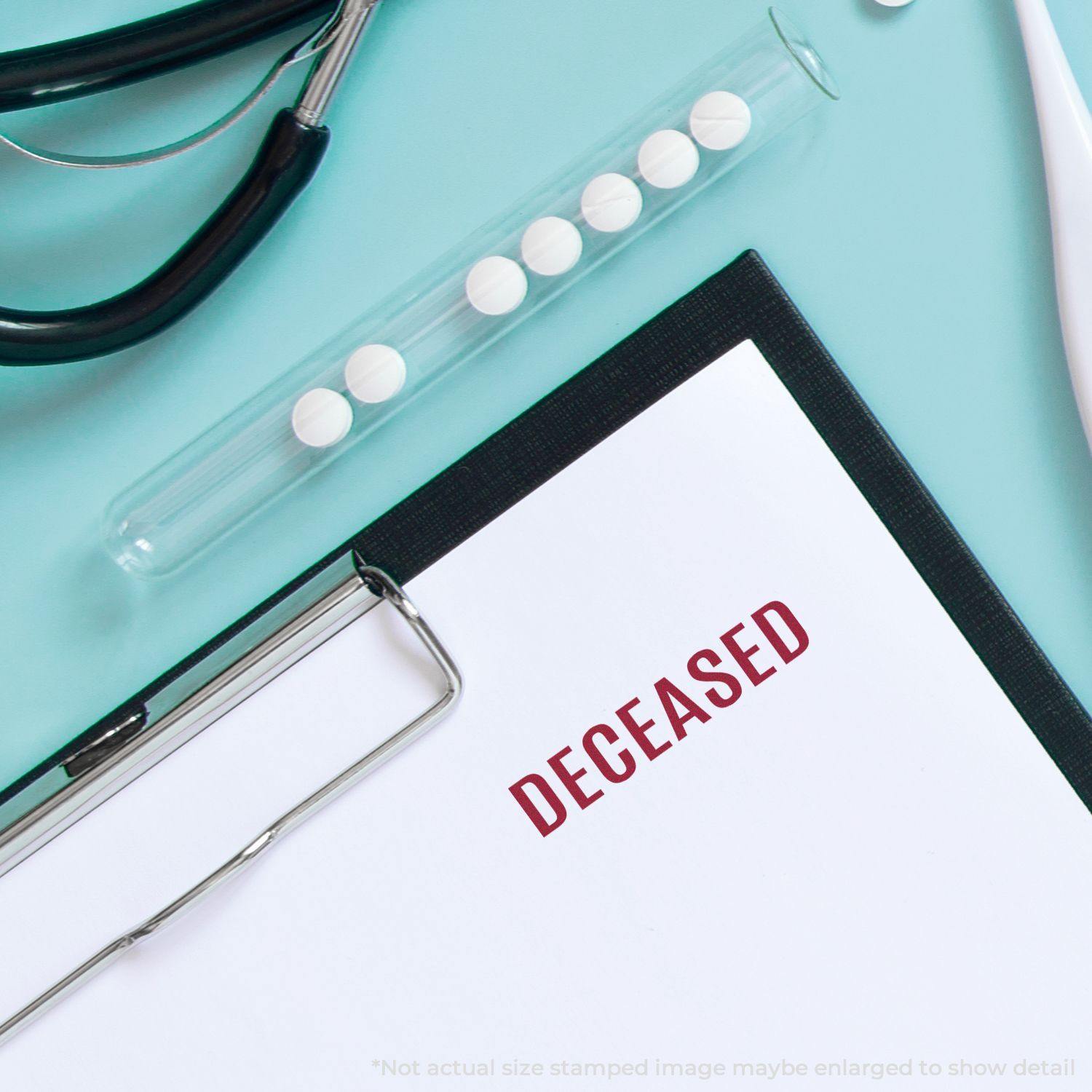 Clipboard with DECEASED stamped in red using the Large Pre-Inked Bold Deceased Stamp, next to medical tools and pills on a blue surface.