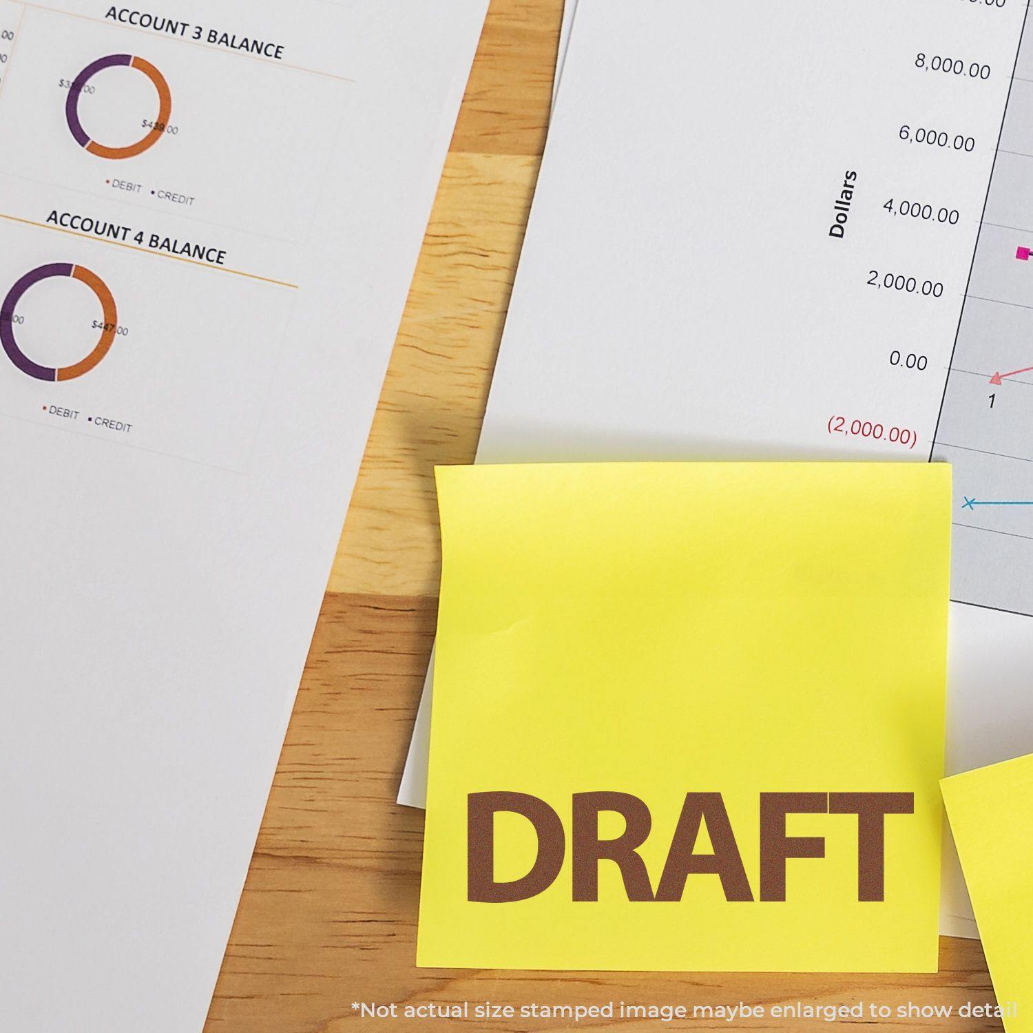 Self Inking Bold Draft Stamp marking DRAFT on a yellow sticky note, with financial documents and charts in the background.