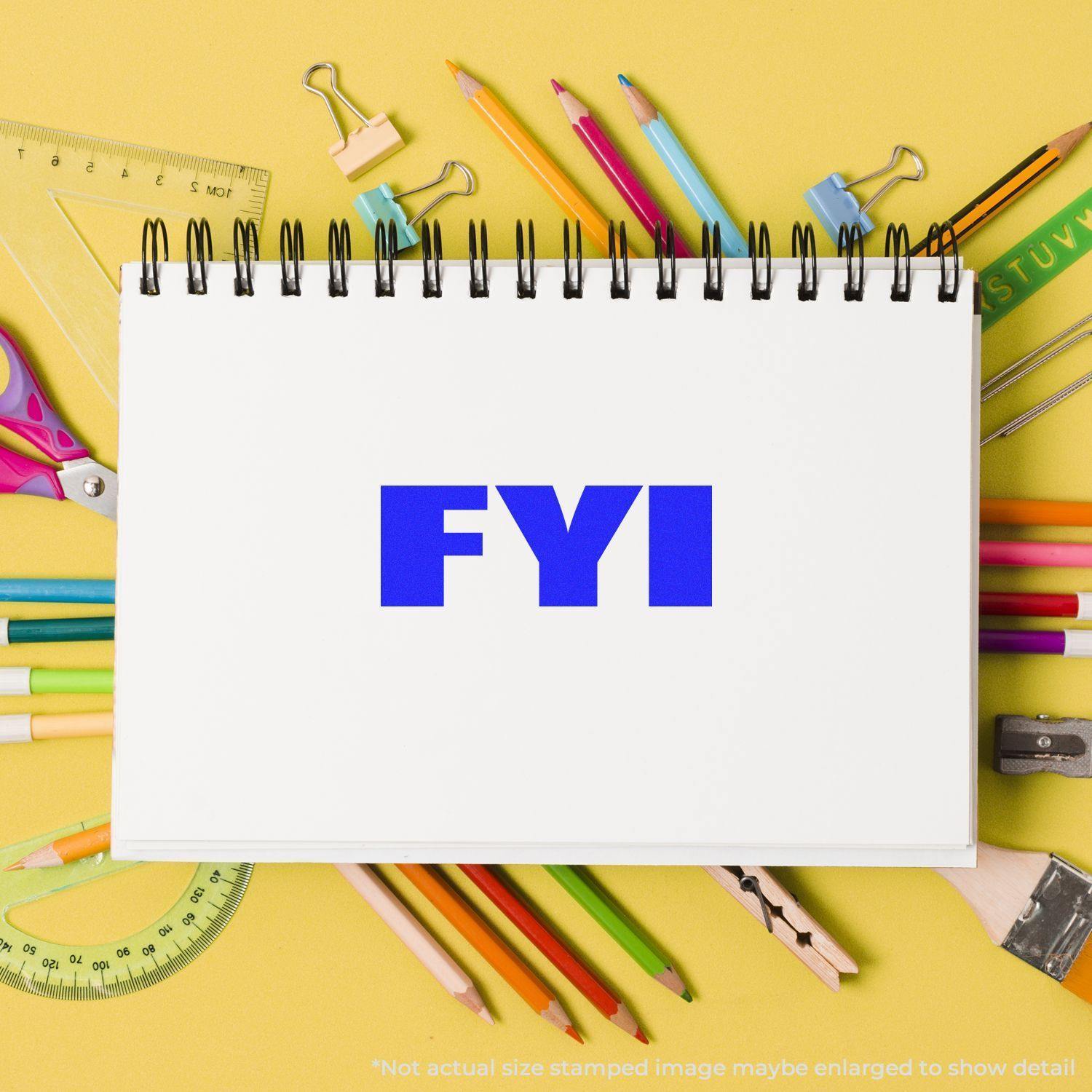 Self Inking Bold FYI Stamp in blue ink on a white notebook, surrounded by colorful stationery on a yellow background.