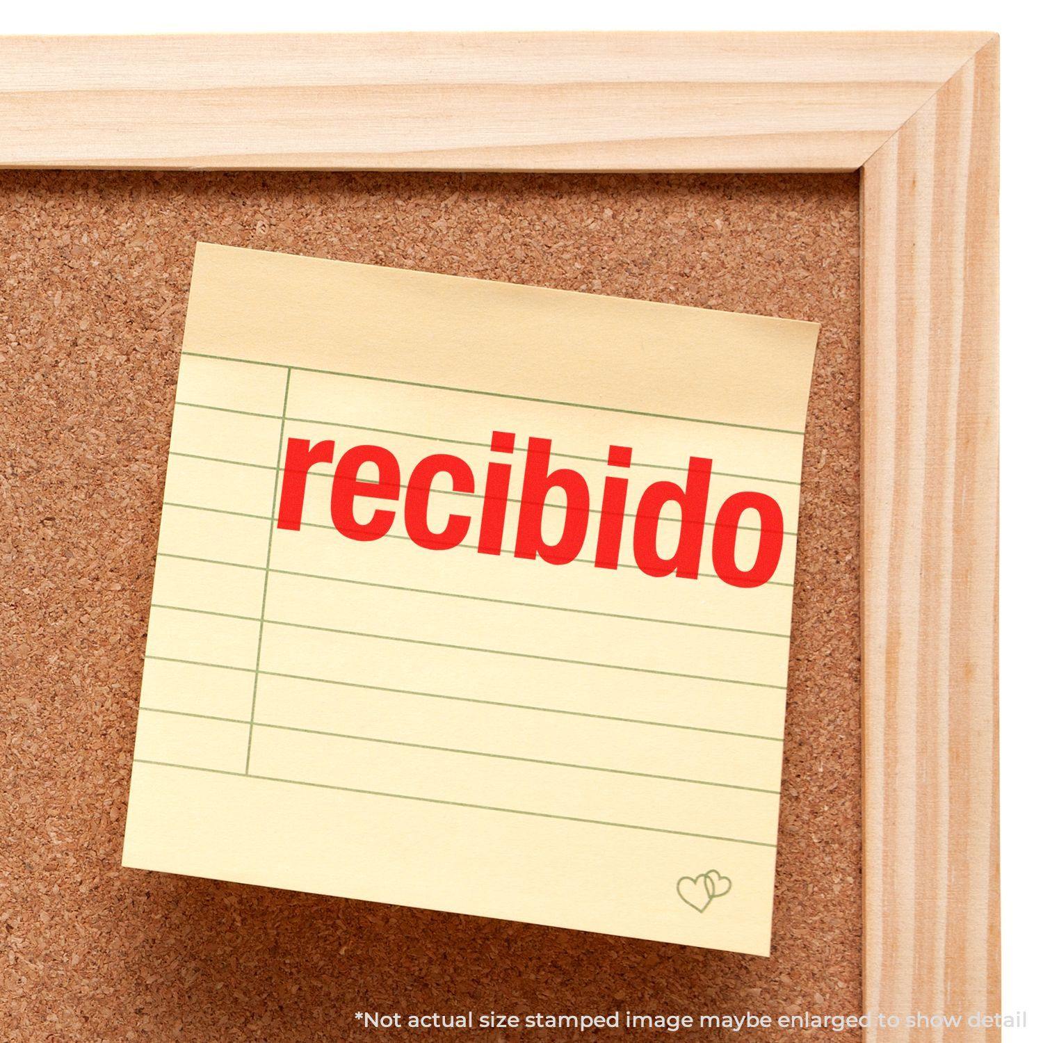 A corkboard with a sticky note stamped recibido in red ink using the Bold Recibido Rubber Stamp.